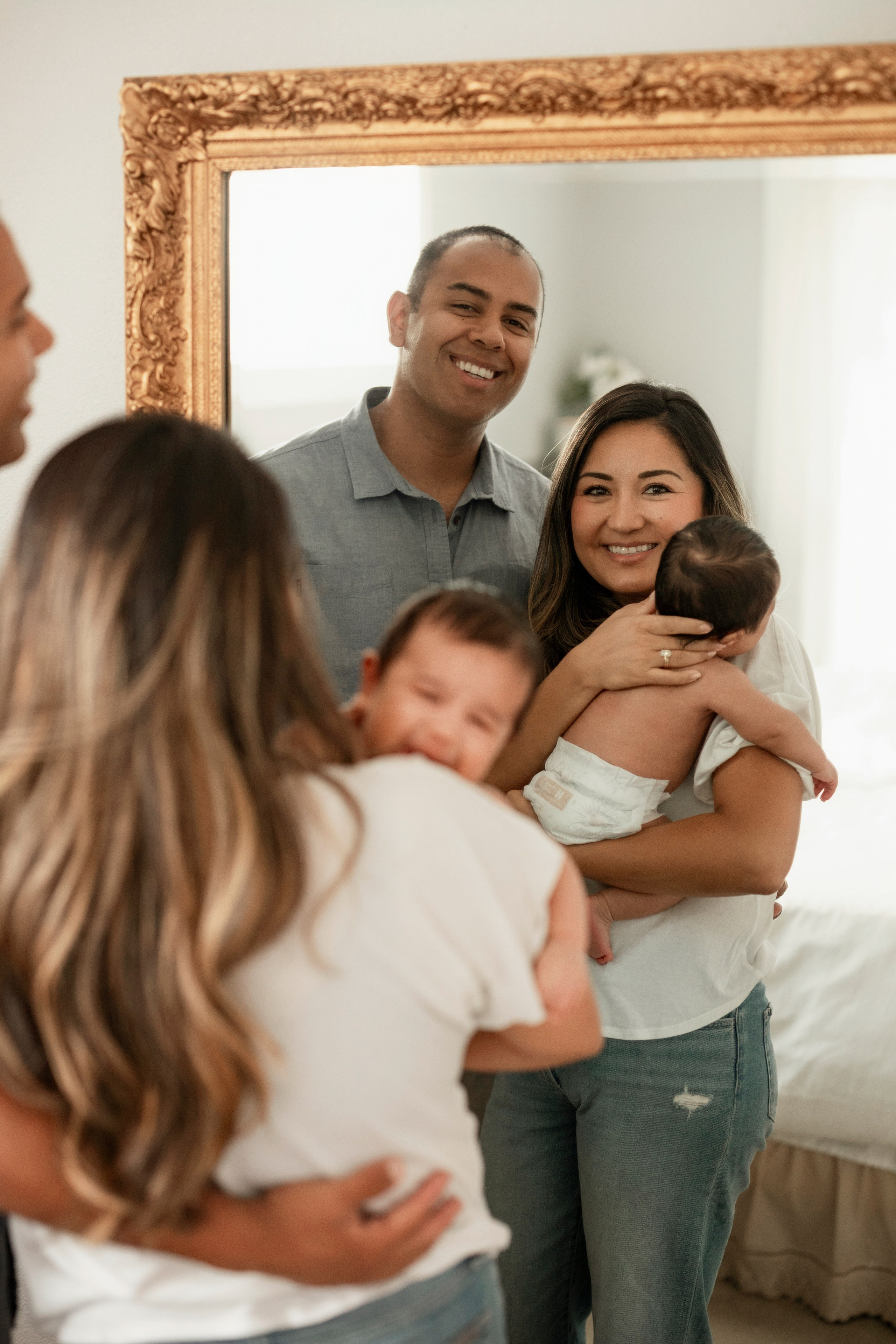 Parents smiling with newborn baby in natural light family photos