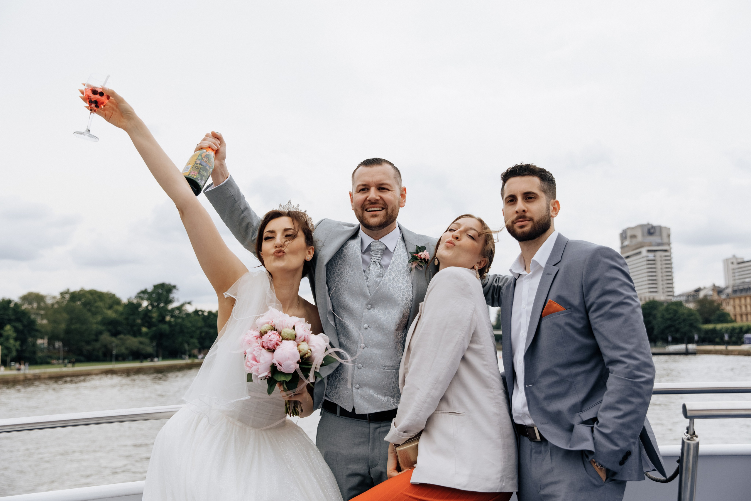 Der Bräutigam, die Braut und ihre Freunde machen lustige Grimassen.