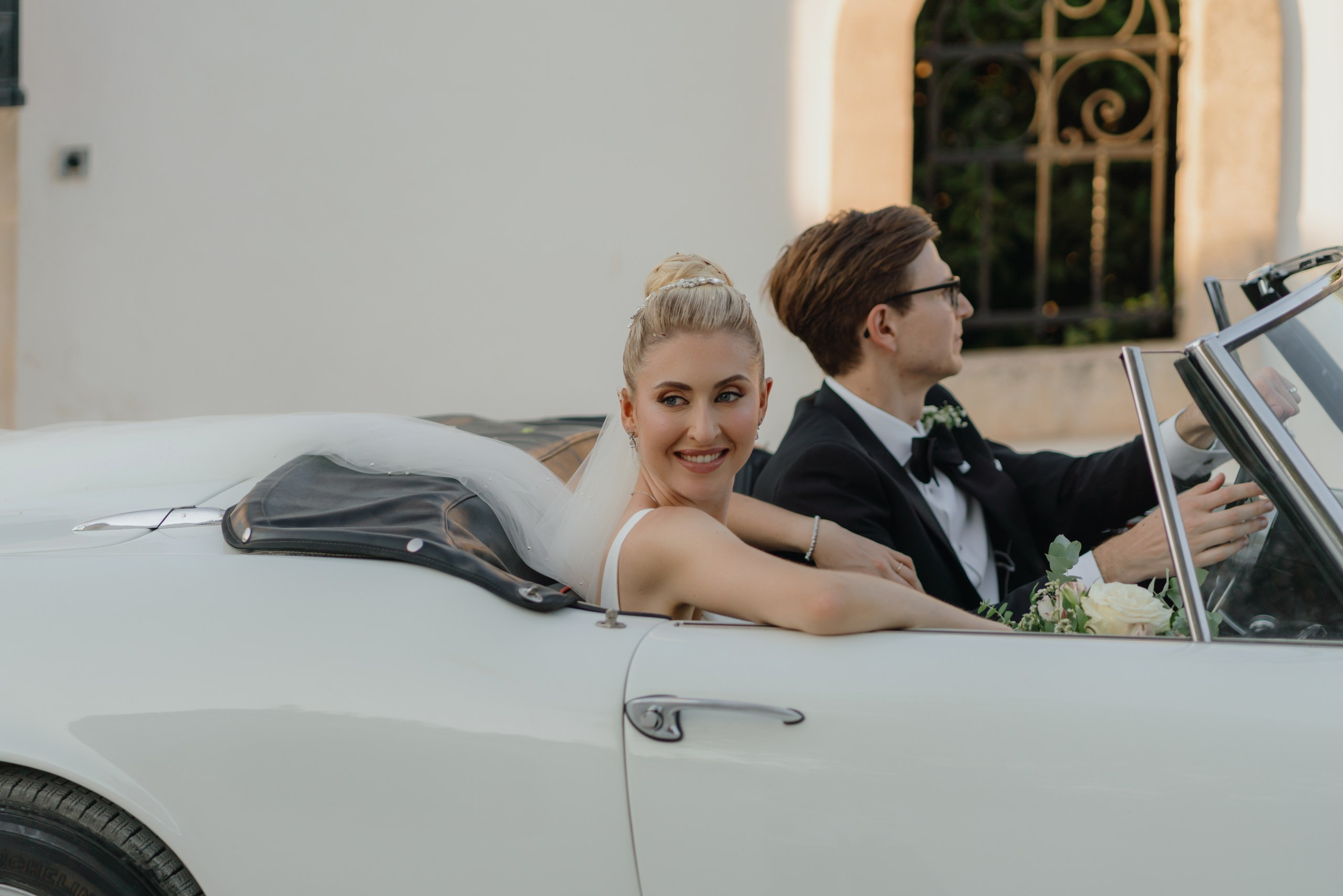 Destination wedding photography with bride and groom in cabriolet Ostuni
