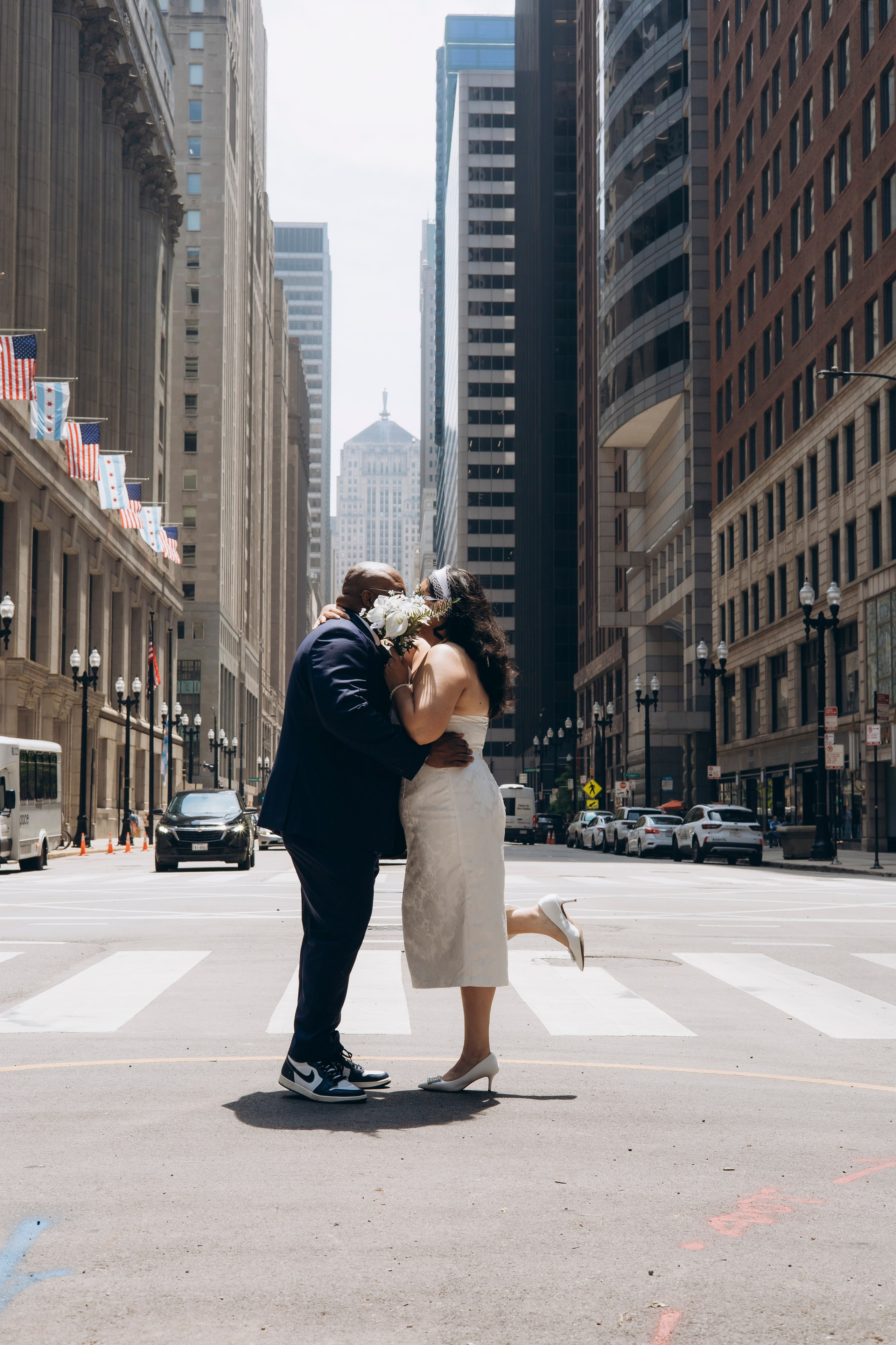 Couple sharing a kiss with bride holding bouquet covering their faces, Chicago