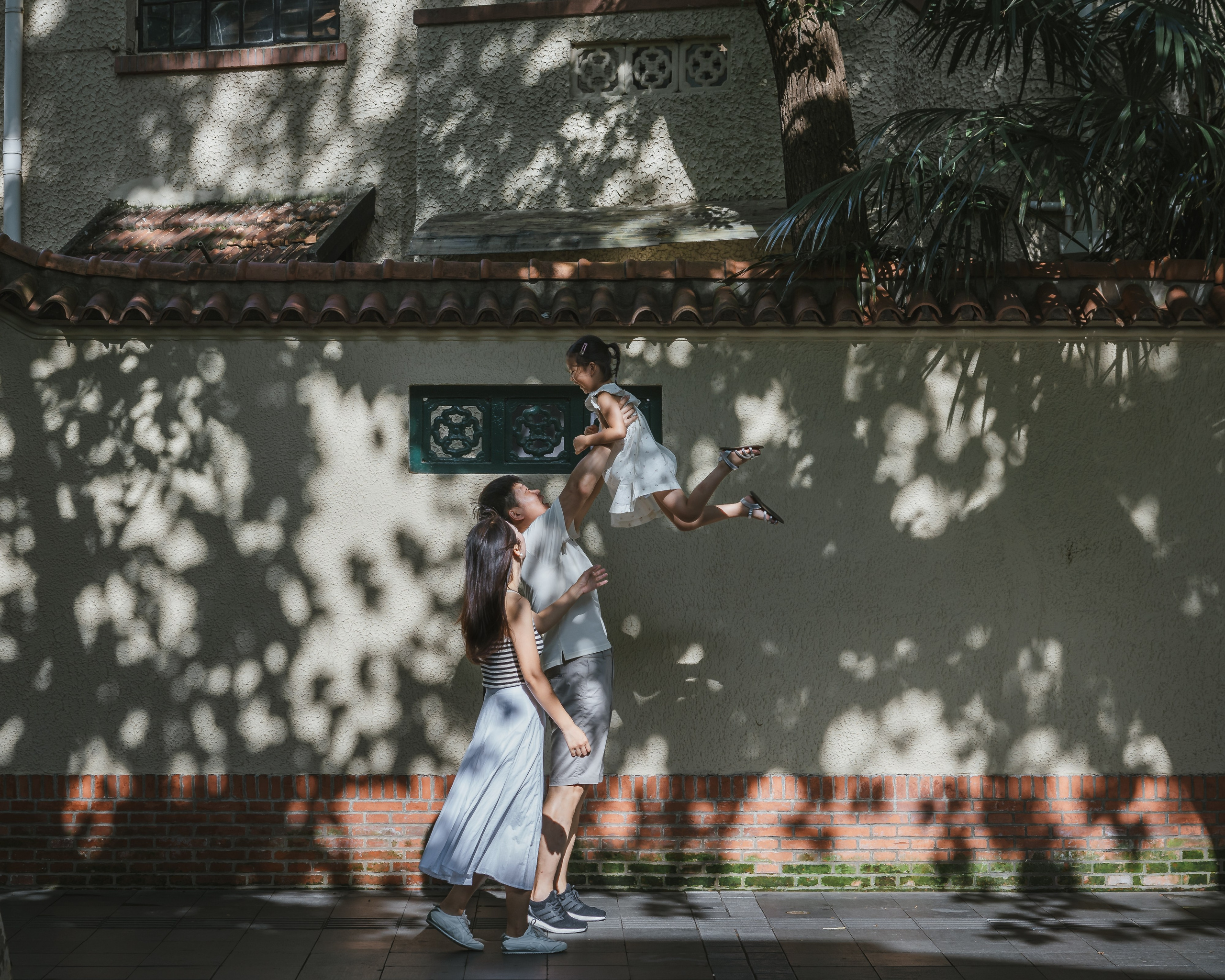 On an old street in Shanghai, the father lifts his daughter high, and I captured the moment.