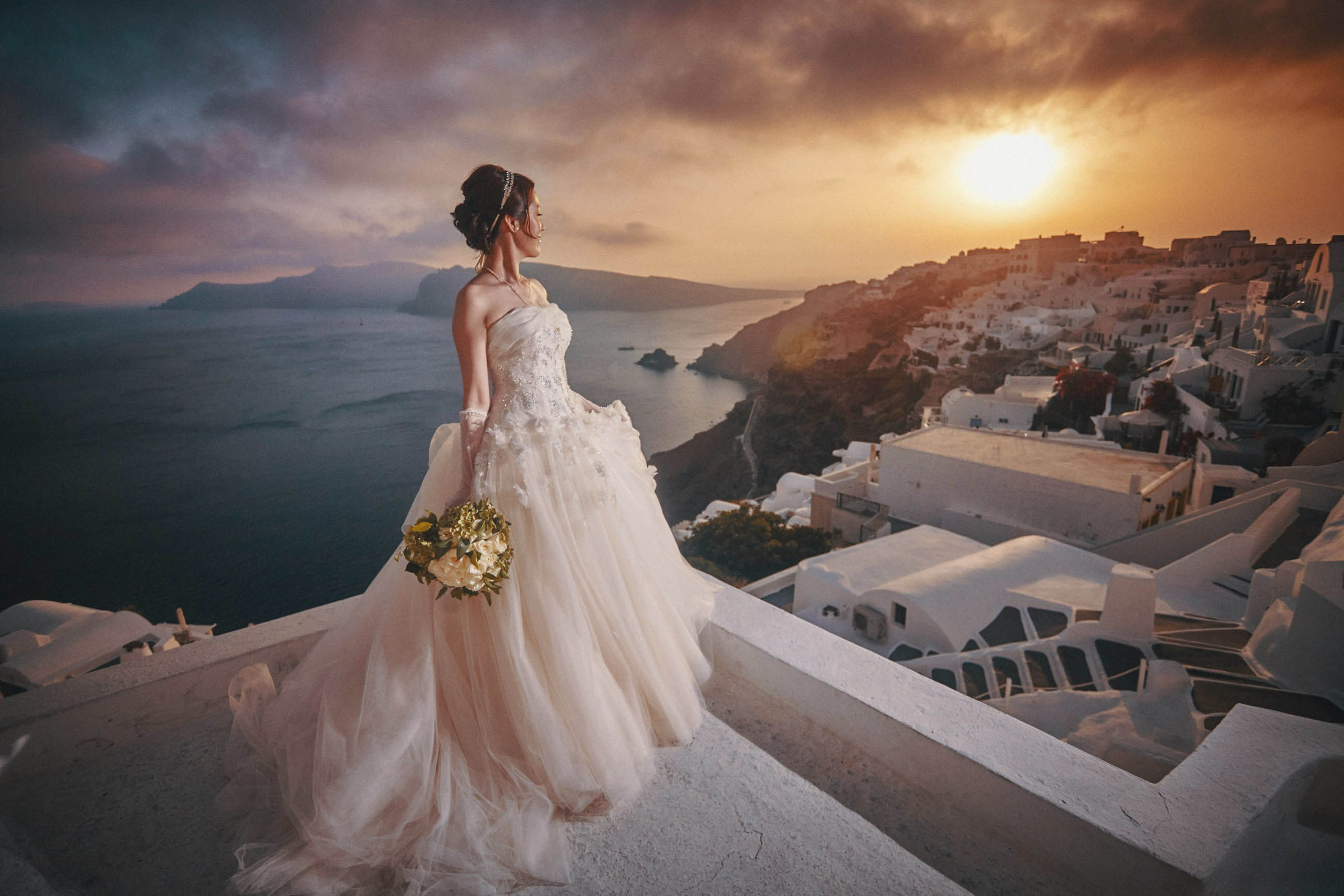 Our beautiful bride from Japan who watches the sunset over Santorini during her evening portrait session. Sometimes the most beautiful images are unplanned
