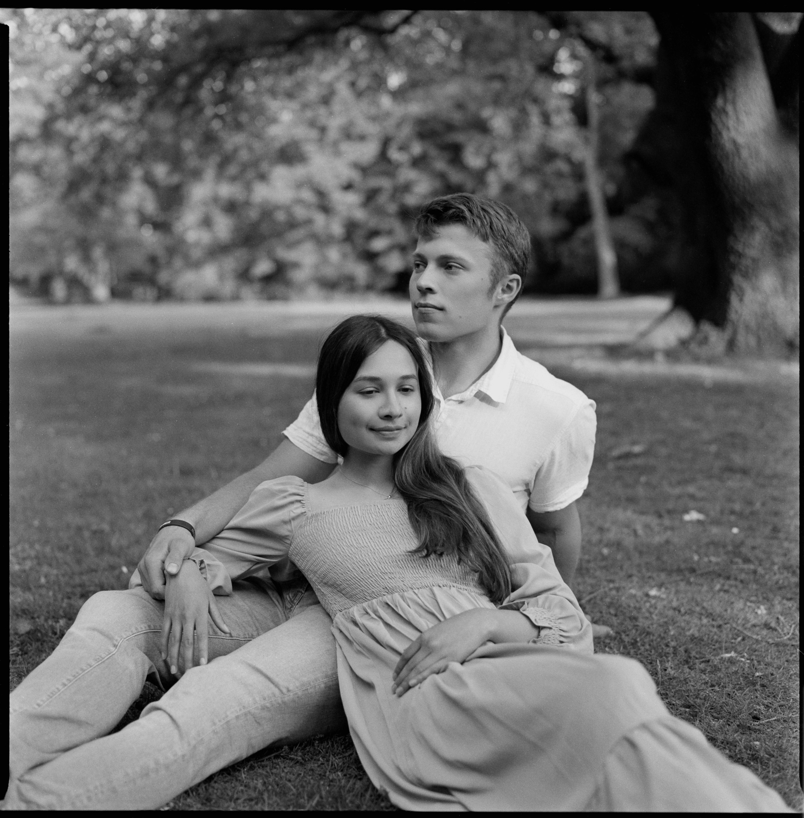 Couple resting on grass in soft natural light, medium format film photo, Bodensee