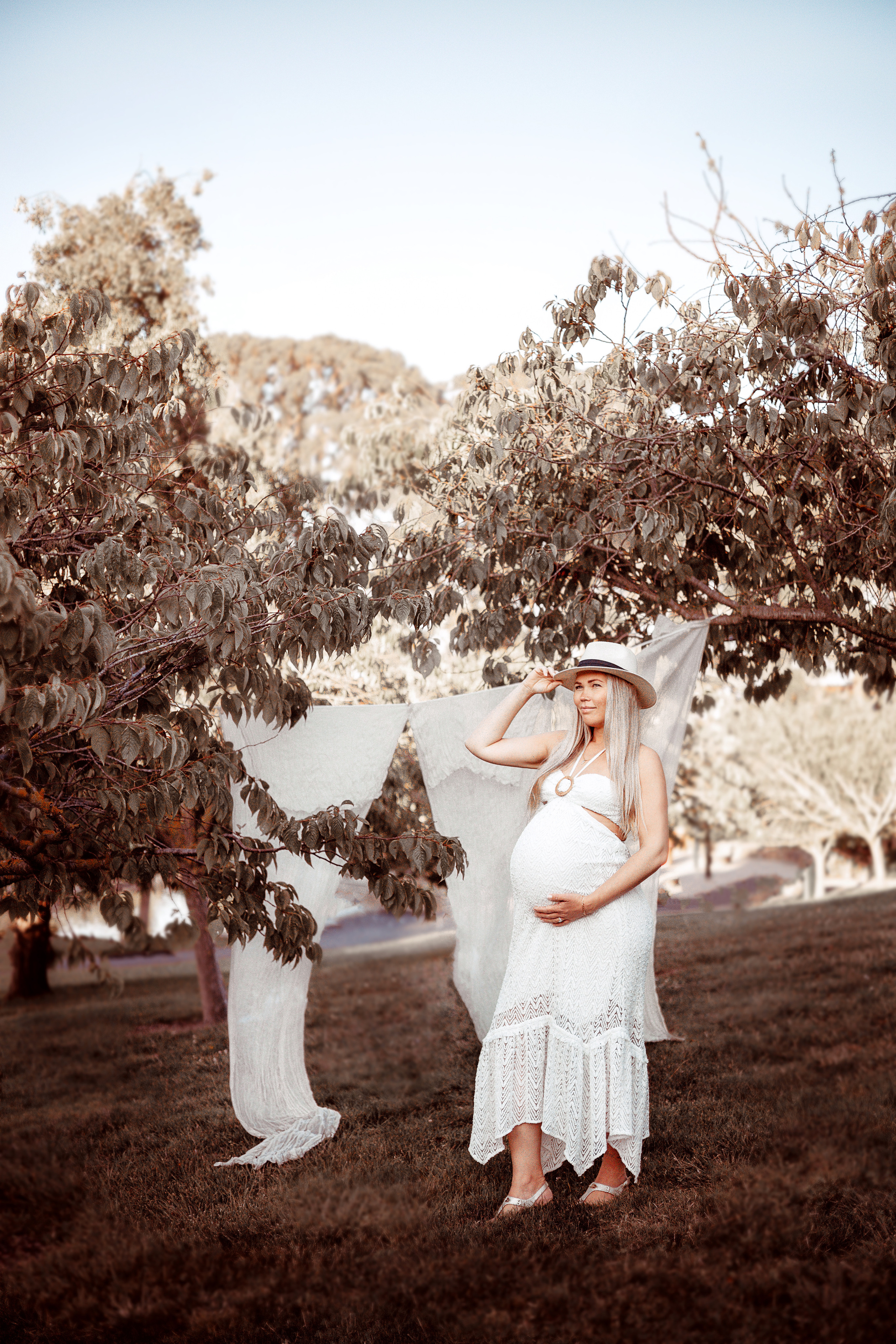 Pregnant woman walking through a park surrounded by greenery
