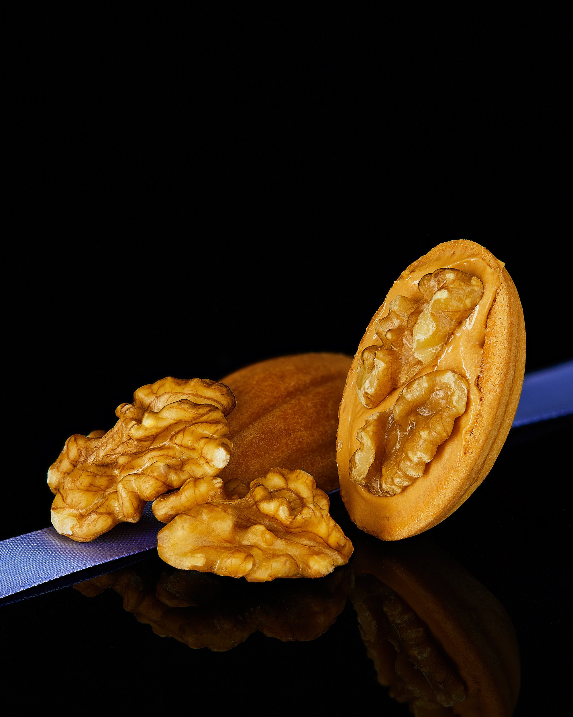Photographer Roman Djuzev - Cookies "Nuts" with boiled condensed milk and walnuts plan on a dark background.