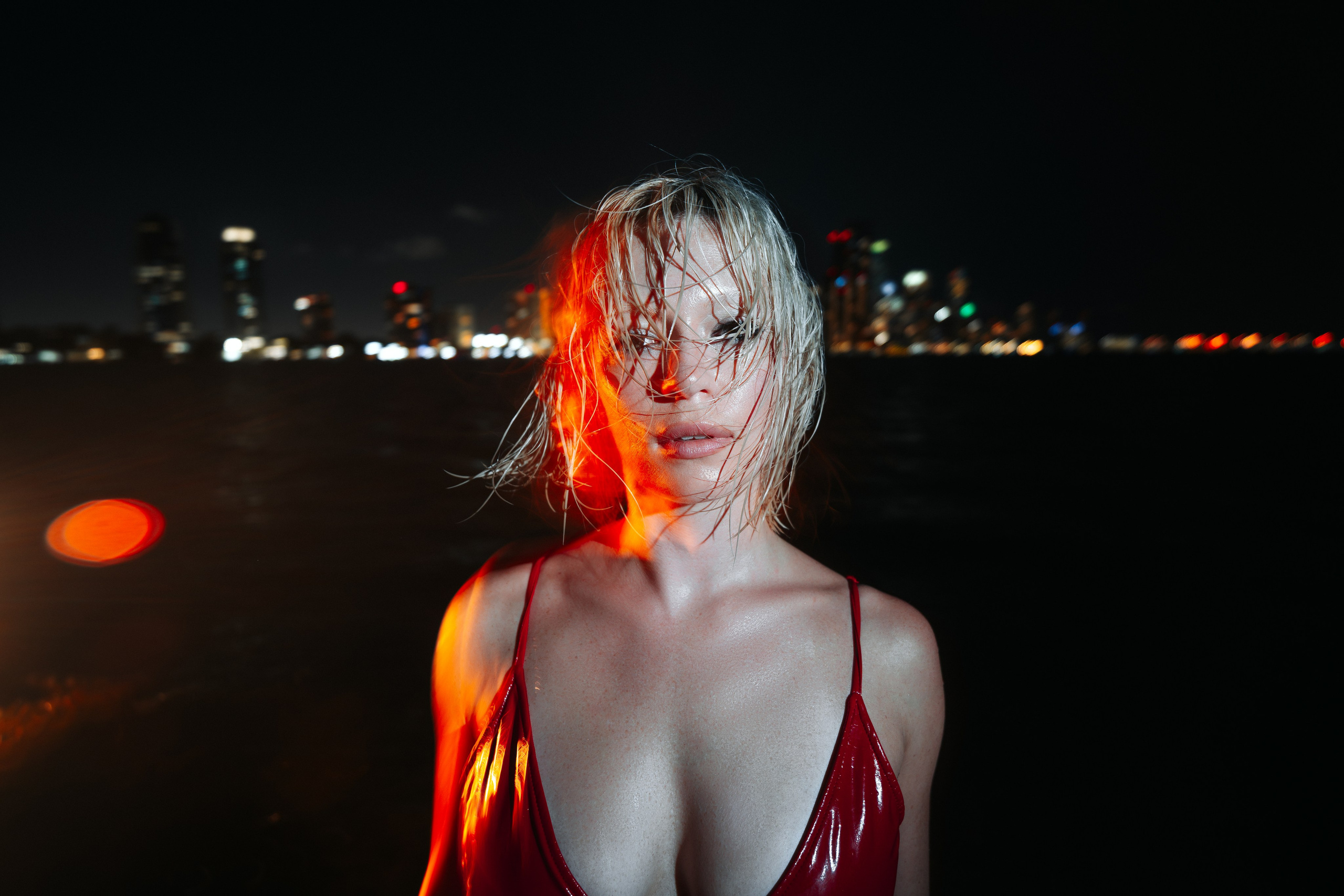 Close-up portrait with wind, water, and a gentle expression, lit with controlled directional light. Professional portrait photography in Miami.