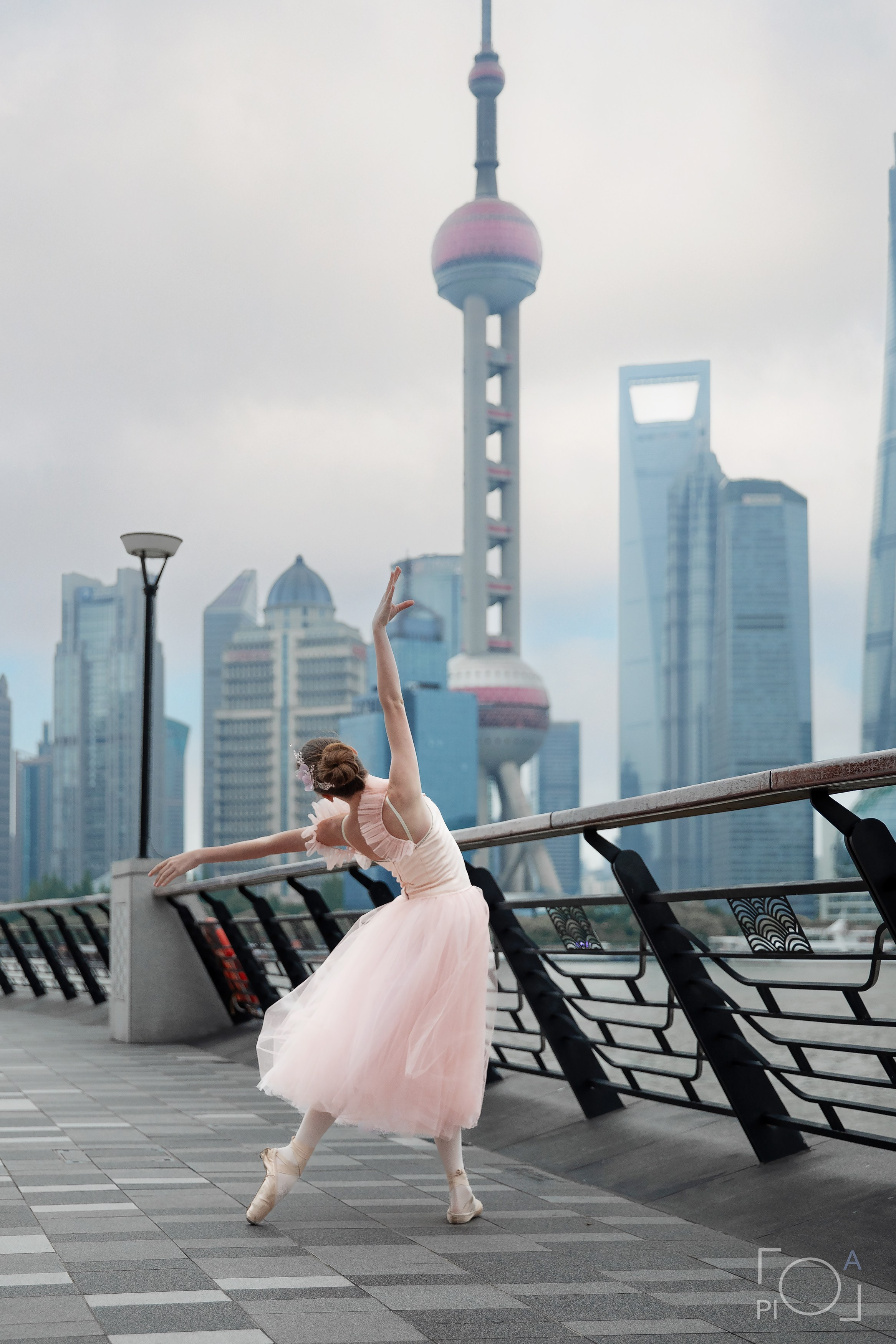 Фотосессия в Шанхае для девочки 11 лет. Маленькая балерина в розовом платье с пышной длинной пачкой, танцует на набережной в Шанхае с видом на Lujiazui