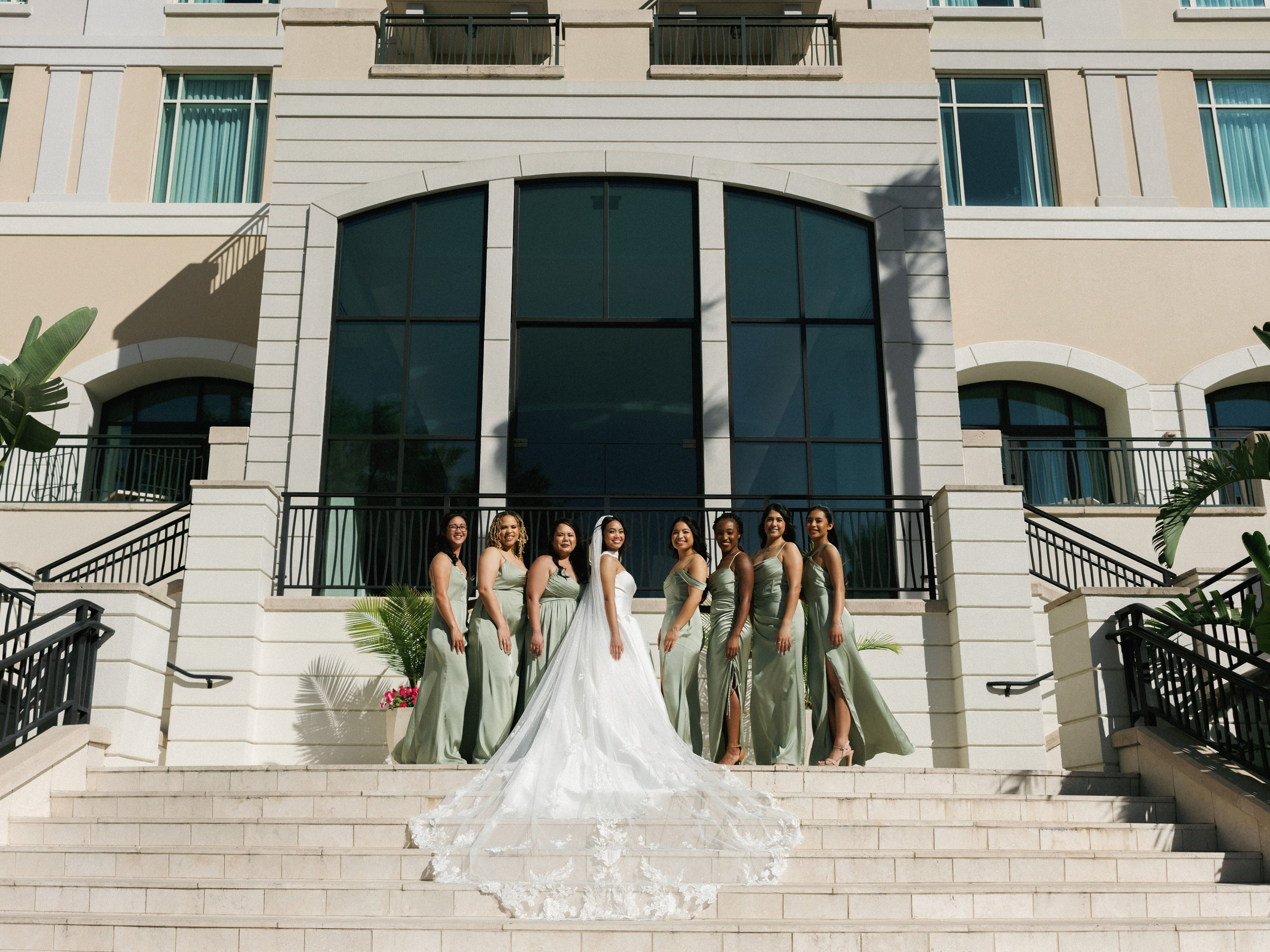 Bride and bridesmaids posed on an outdoor staircase at an elegant wedding venue