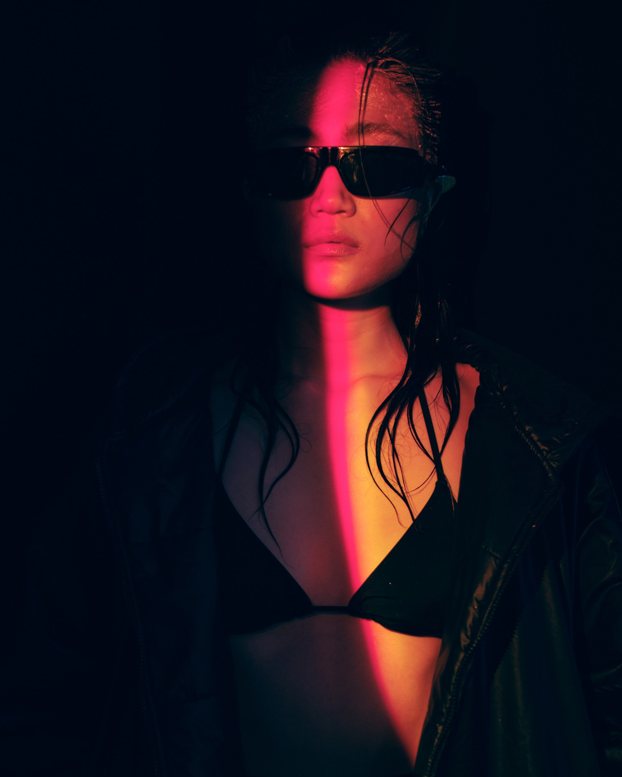 Cinematic high-fashion portrait with bold sunglasses and dramatic red lighting effect