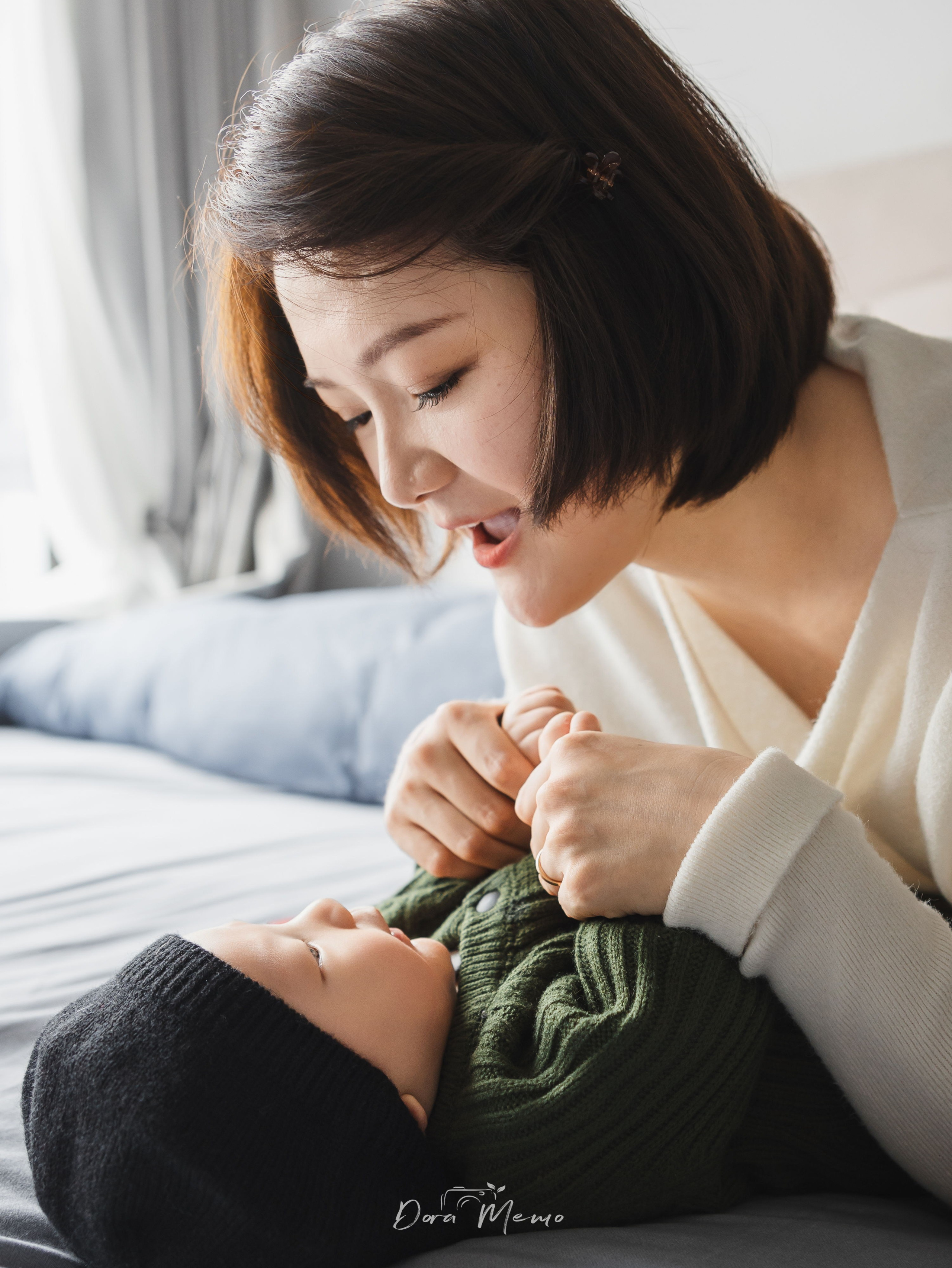 Mother playing with baby on bed, soft natural light family photography Shanghai