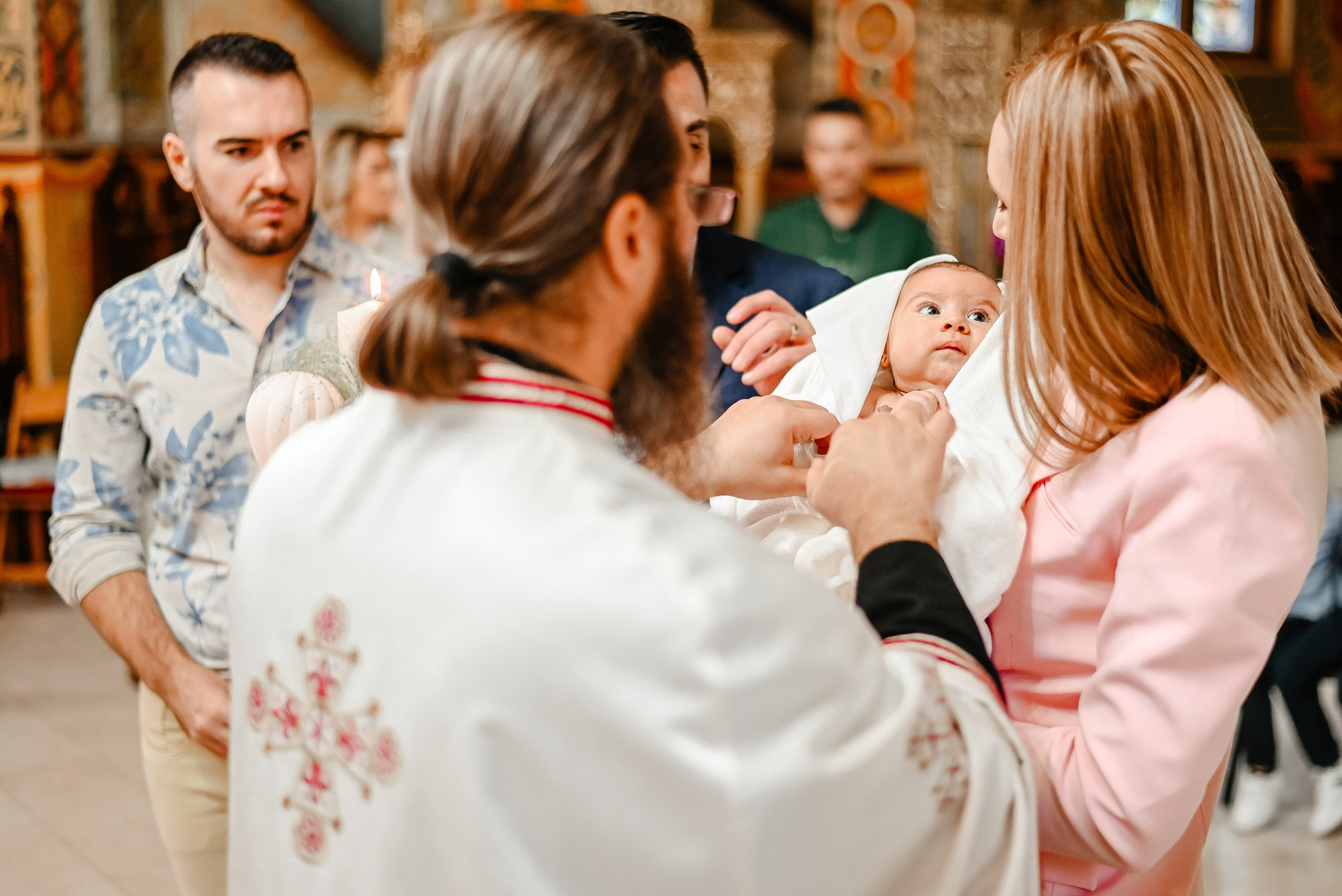 Preot binecuvântând copilul în timpul botezului – fotografie Ana Maria Drăgan