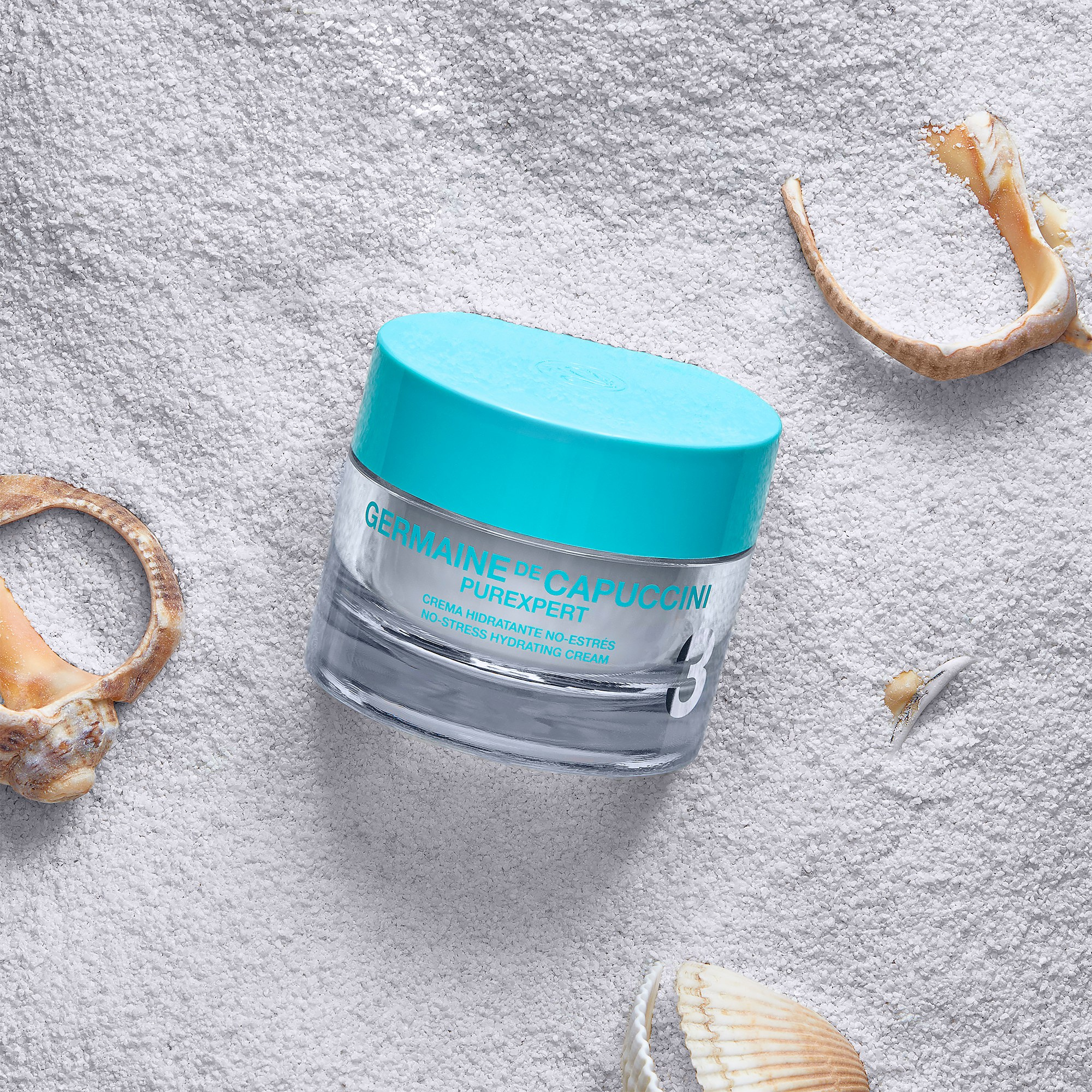 Photographer Roman Djuzev - Germaine De Capuccini cream on white sand with seashells, top view.