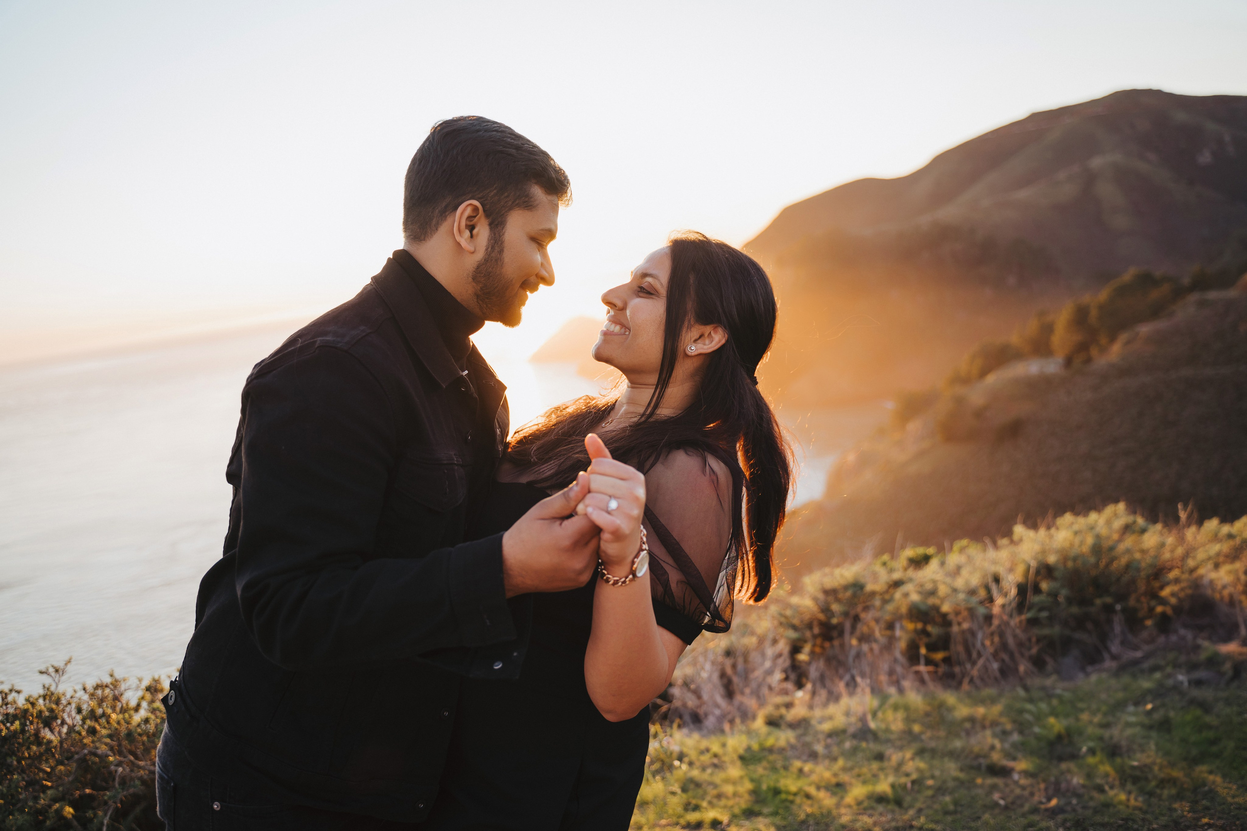 Proposal.  Overlooking the golden San Franisco Bridge sunset with a couple. Photographer Video. 