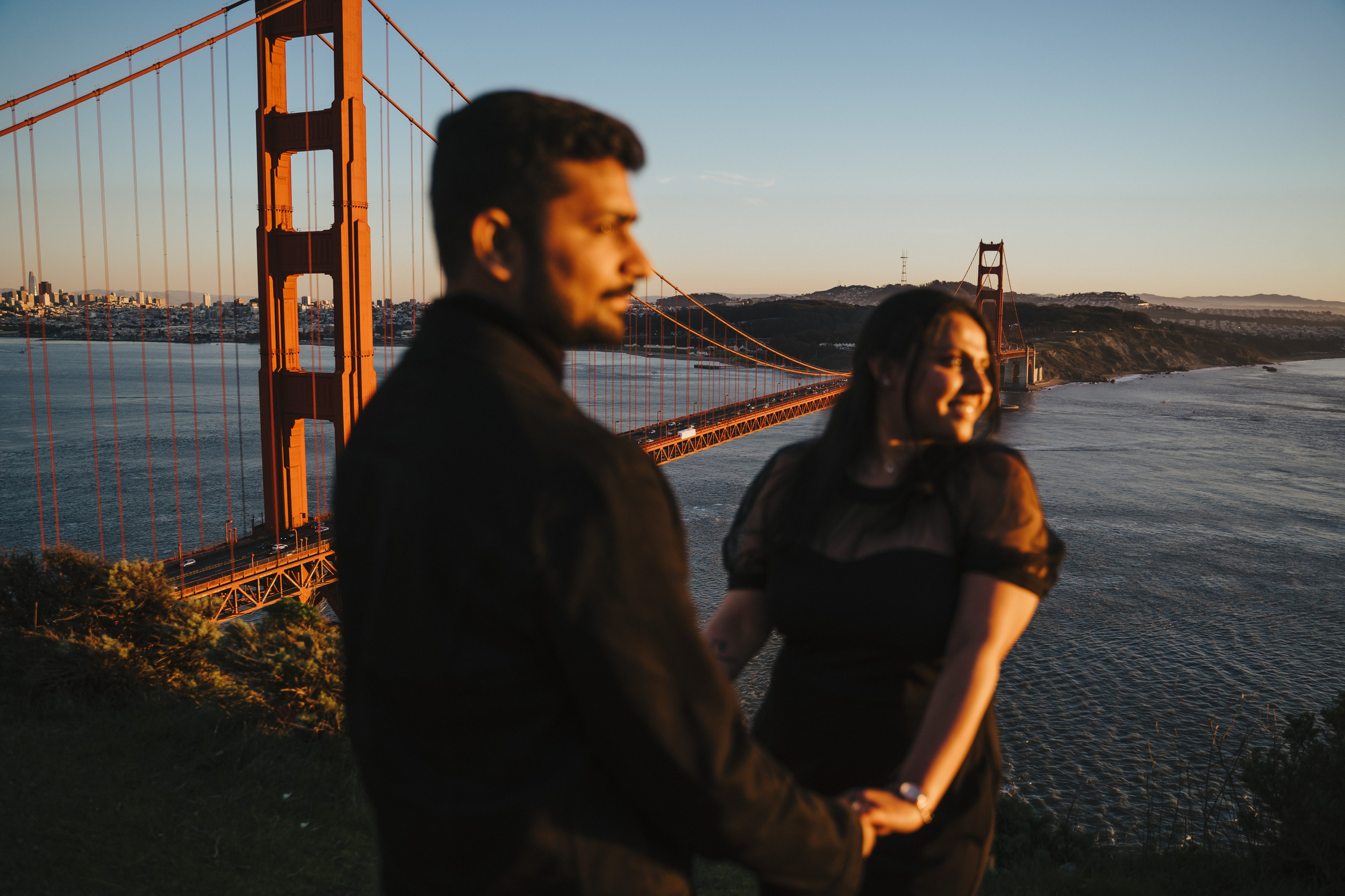 Proposal.  Overlooking the golden San Franisco Bridge sunset with a couple. Photographer Video. 