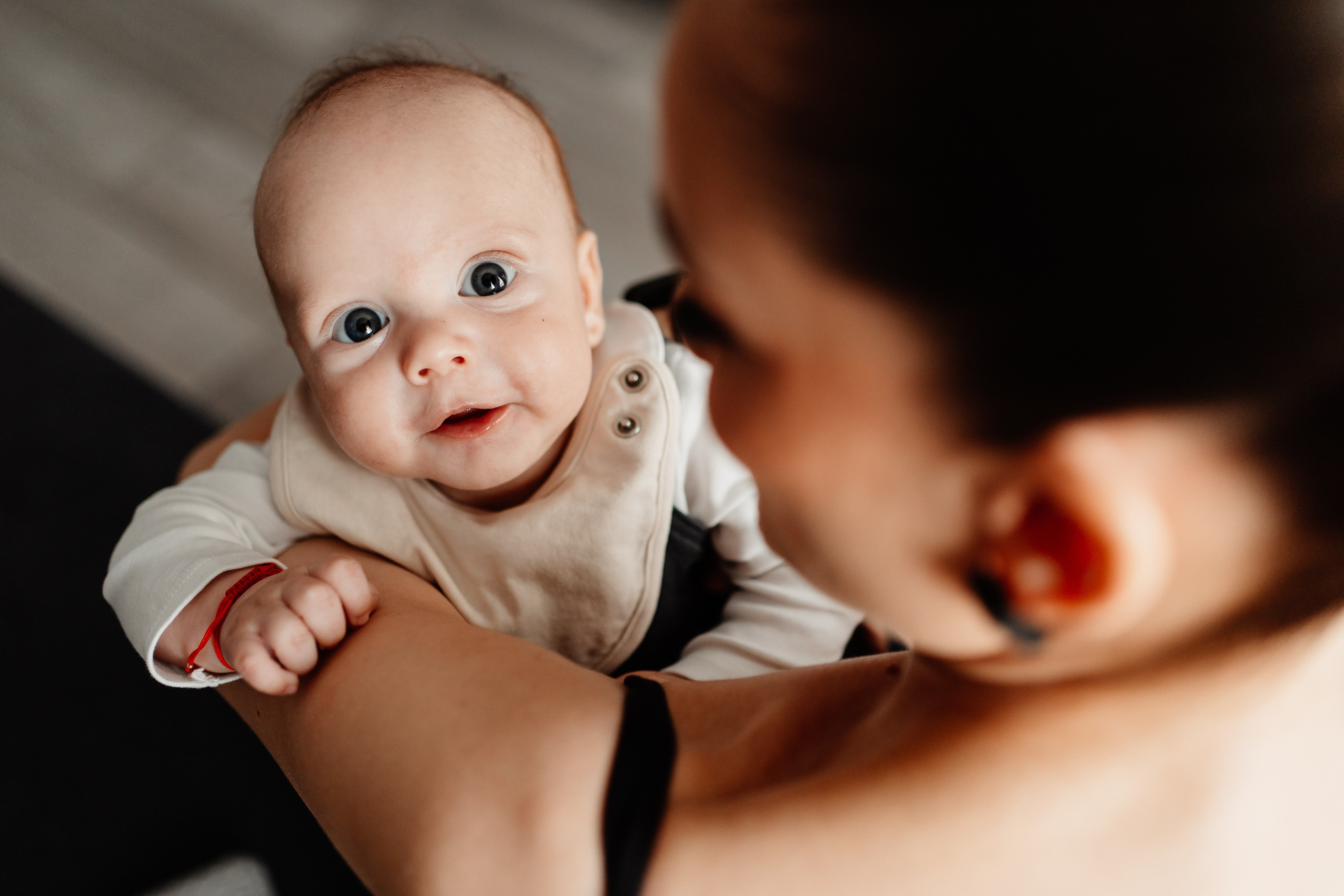 Instantaneu plin de tandrețe dintre părinți și bebeluș în ziua botezului, realizat în Craiova. Fotografie profesională de botez, capturând emoțiile autentice ale familiei într-un decor luminos și cald