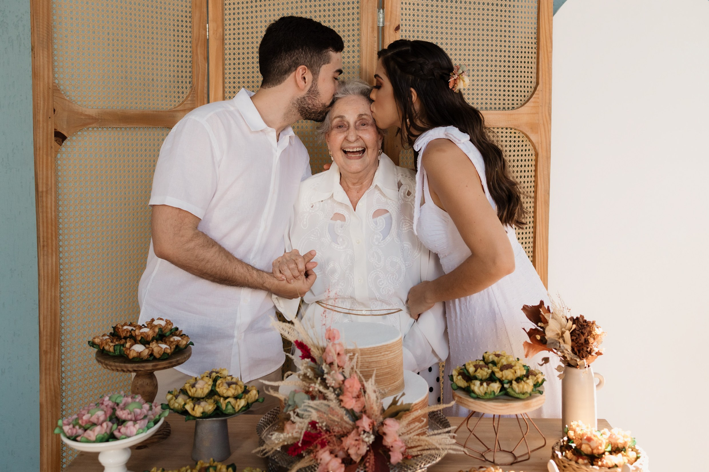 Netos beijando a avó, que sorri feliz