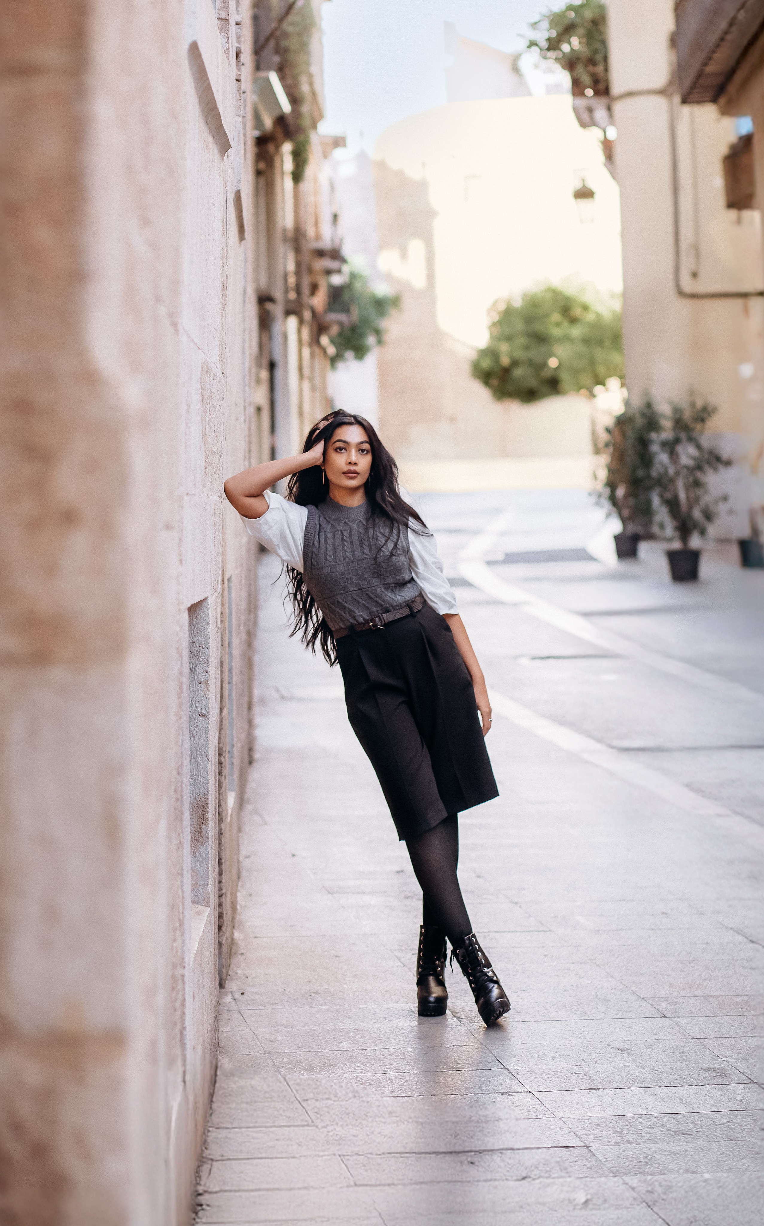Стильная женская портретная фотосессия на уютной улице Валенсии, Испания — современная мода и уверенная поза. Идеально для тех, кто ищет женскую портретную съемку в Валенсии и Испании с городской и элегантной атмосферой.