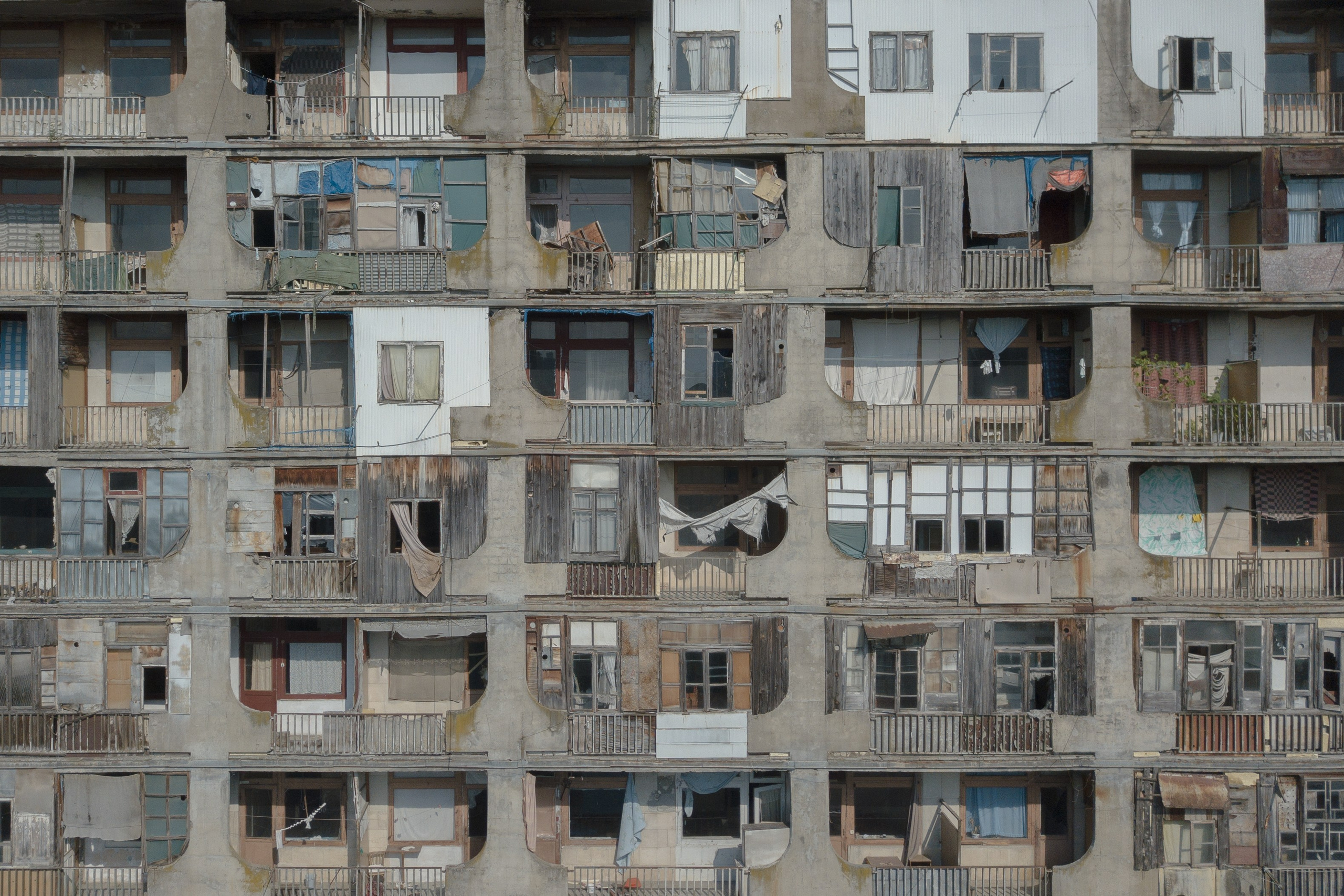 The windows of the sanatorium "Samgurali". Sanatoriums are not adapted for permanent accommodation. There is no hot water and heating. To warm up in winter and cook food, refugees installed stoves on the balconies that they converted into the kitchen. The balconies were open. To insulate them, people built a wall and a window from materials that were at hand.
