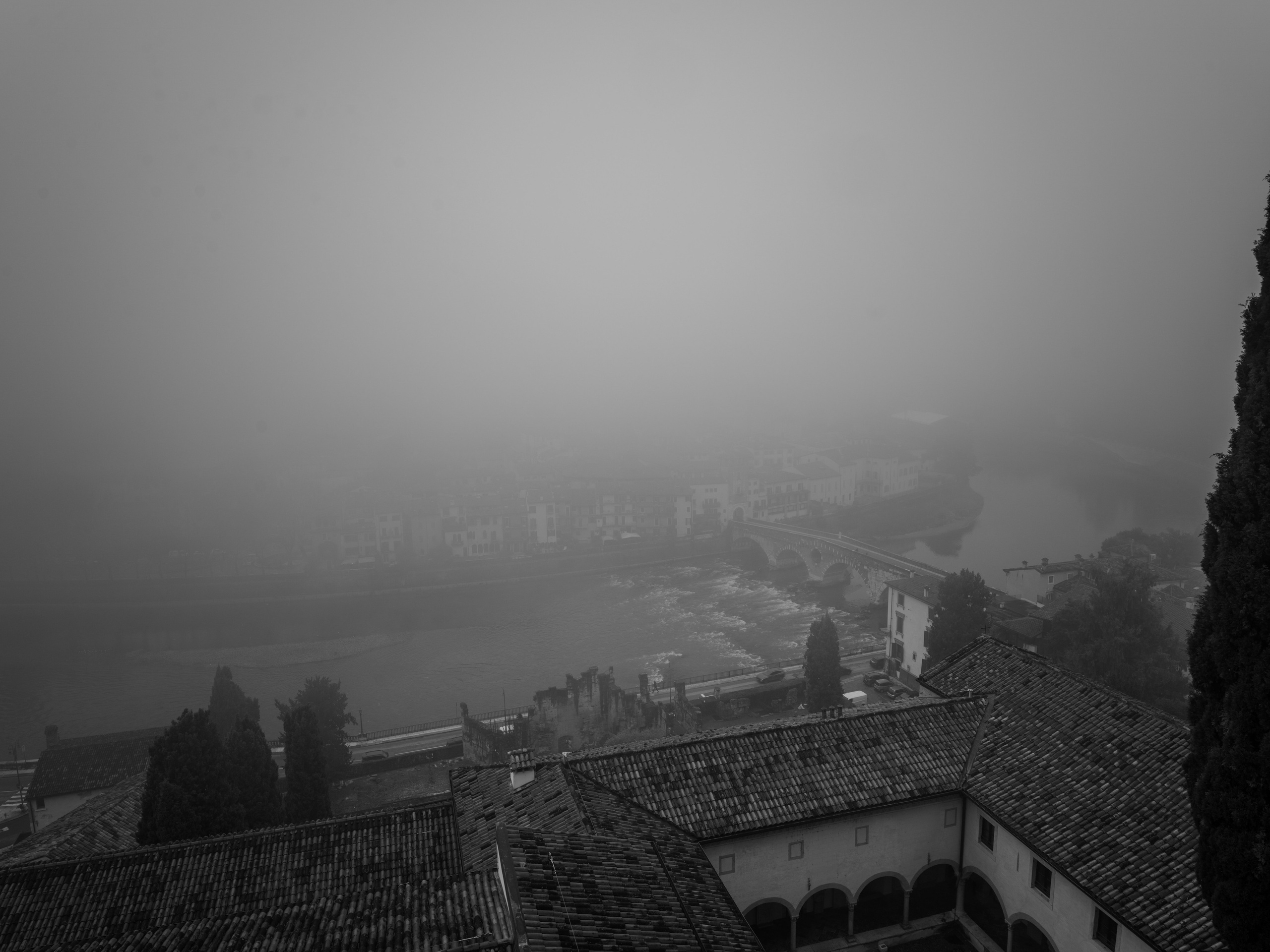 An atmospheric black and white panorama of Verona dissolving into winter fog. Minimalist fine art architecture capturing silence, depth and timeless space.