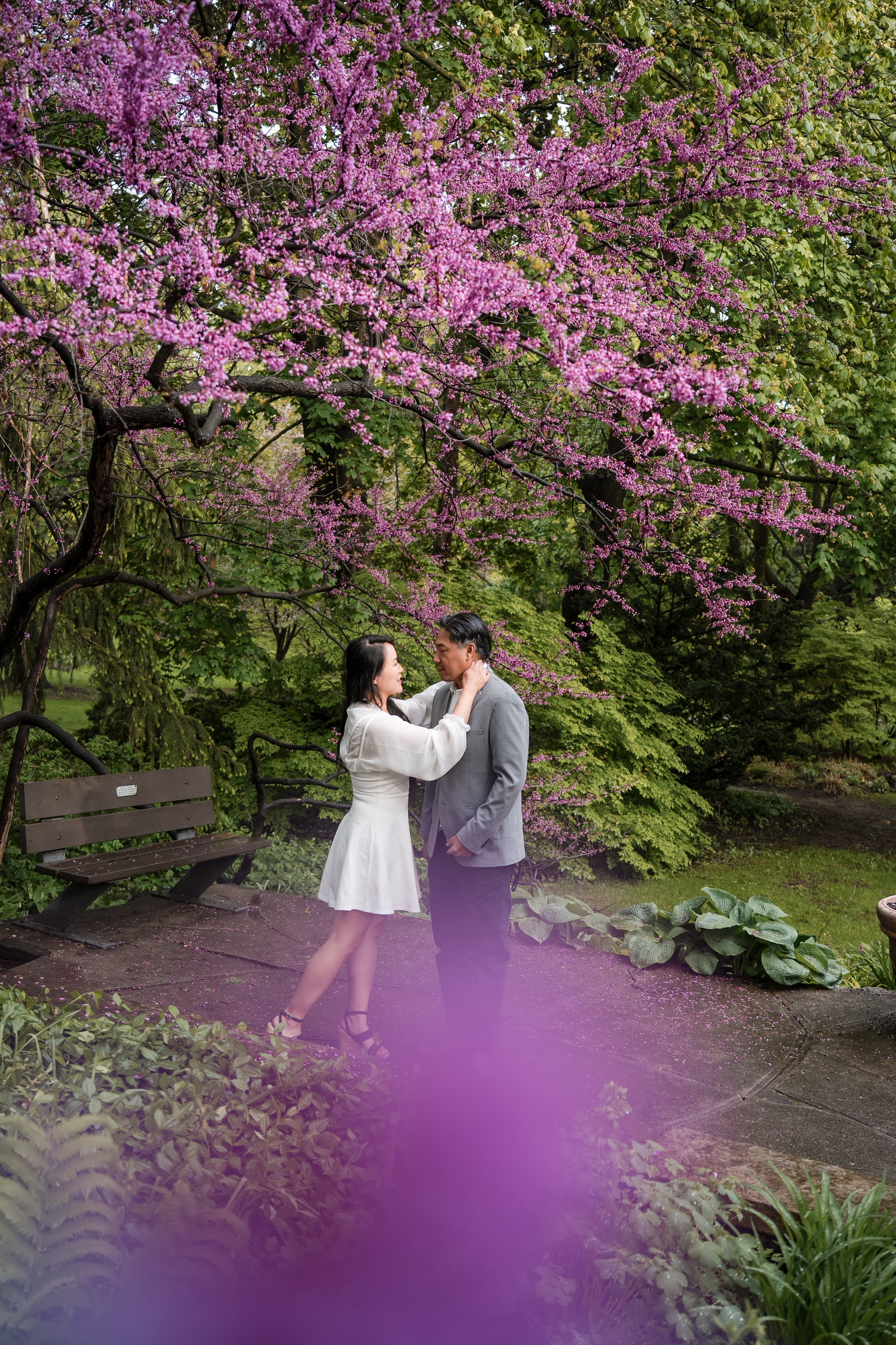 Playful engagement photo in a blooming spring garden, full of laughter and connection