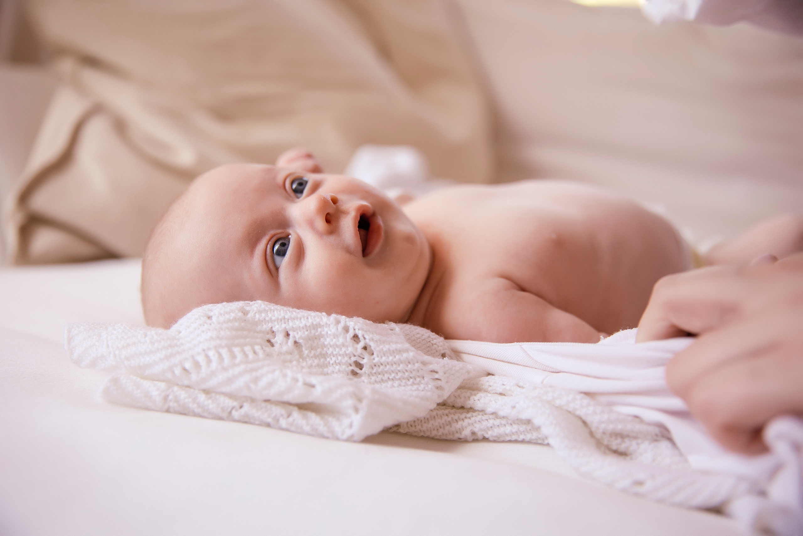Adorable newborn baby resting on the bed.