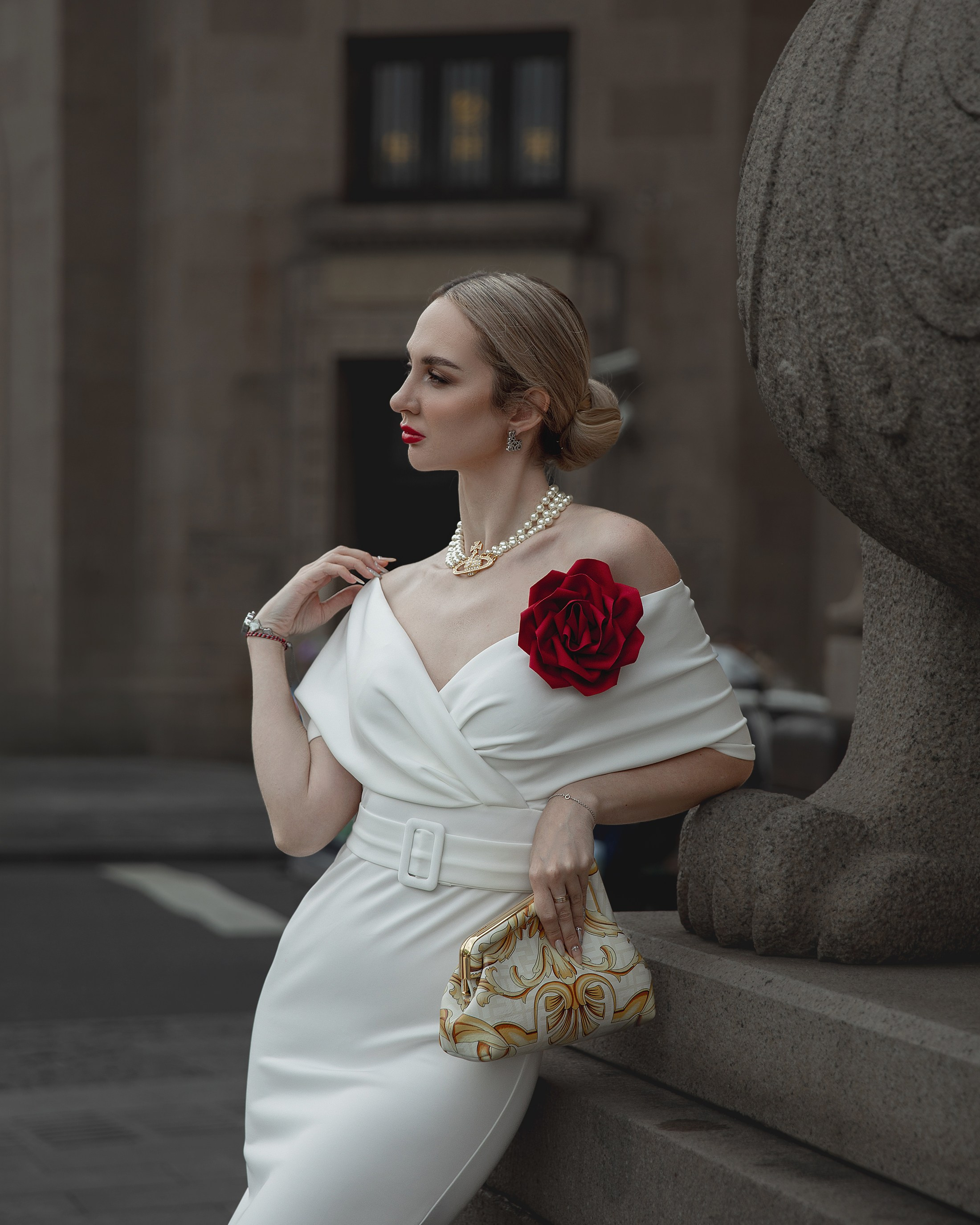 Romantic and glamorous photo shoot for a charming model. Girl in white dress with red big flower on her chest. The Bund, Shanghai