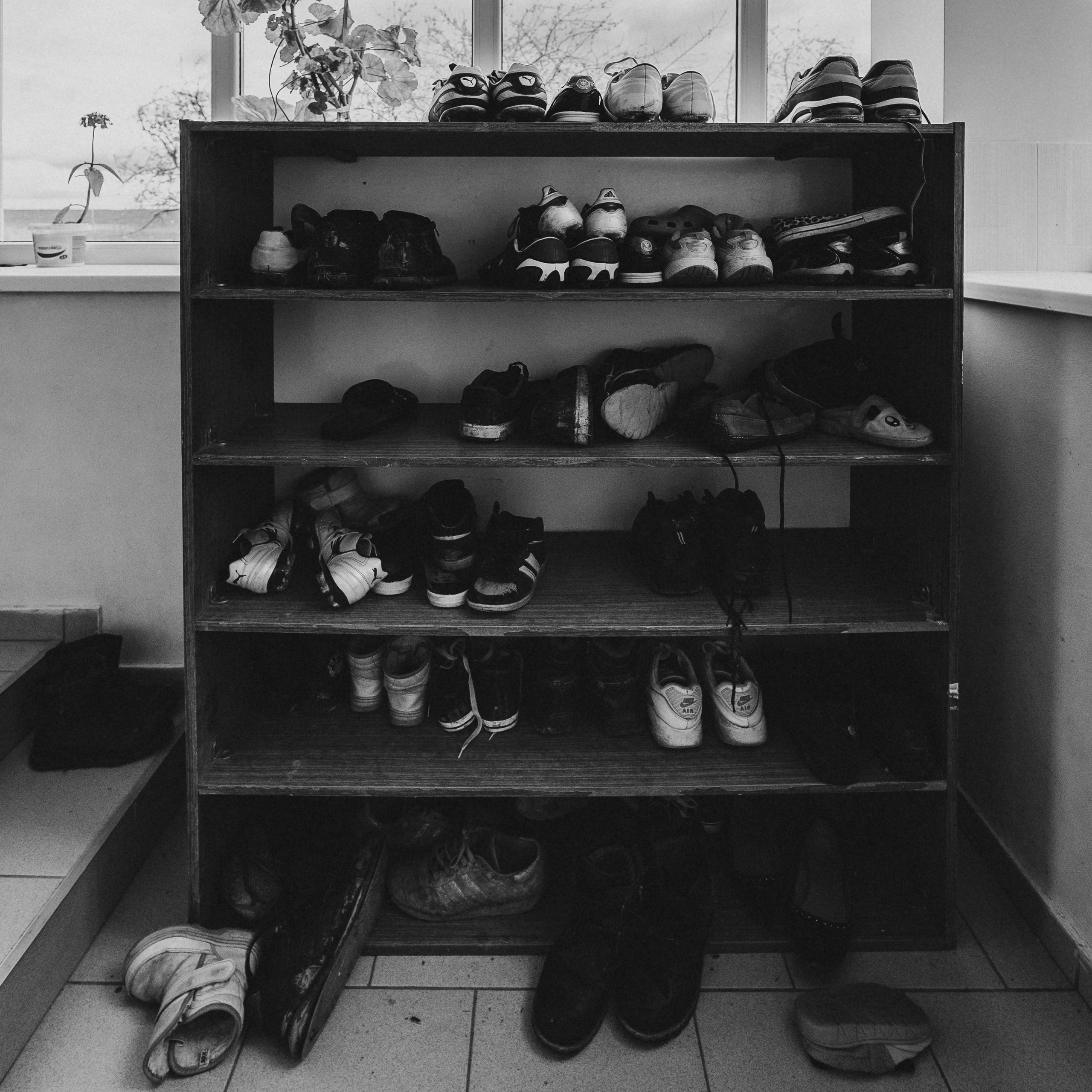 Шкаф с обувью чёрно-белая Детский дом детская обувь разбросанная   социальная фотография