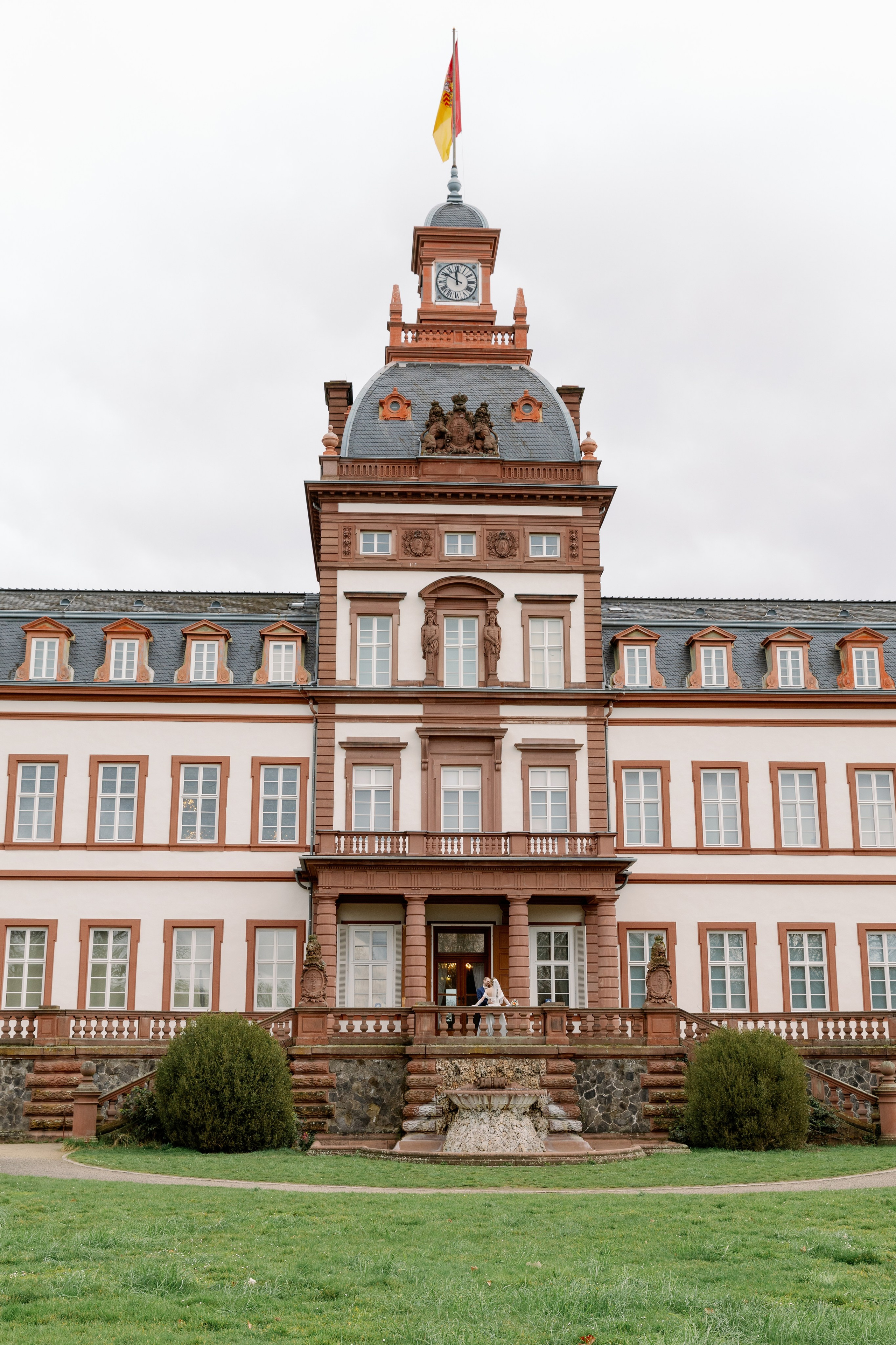 Brautpaar vor der historischen Fassade von Schloss Philippsruhe