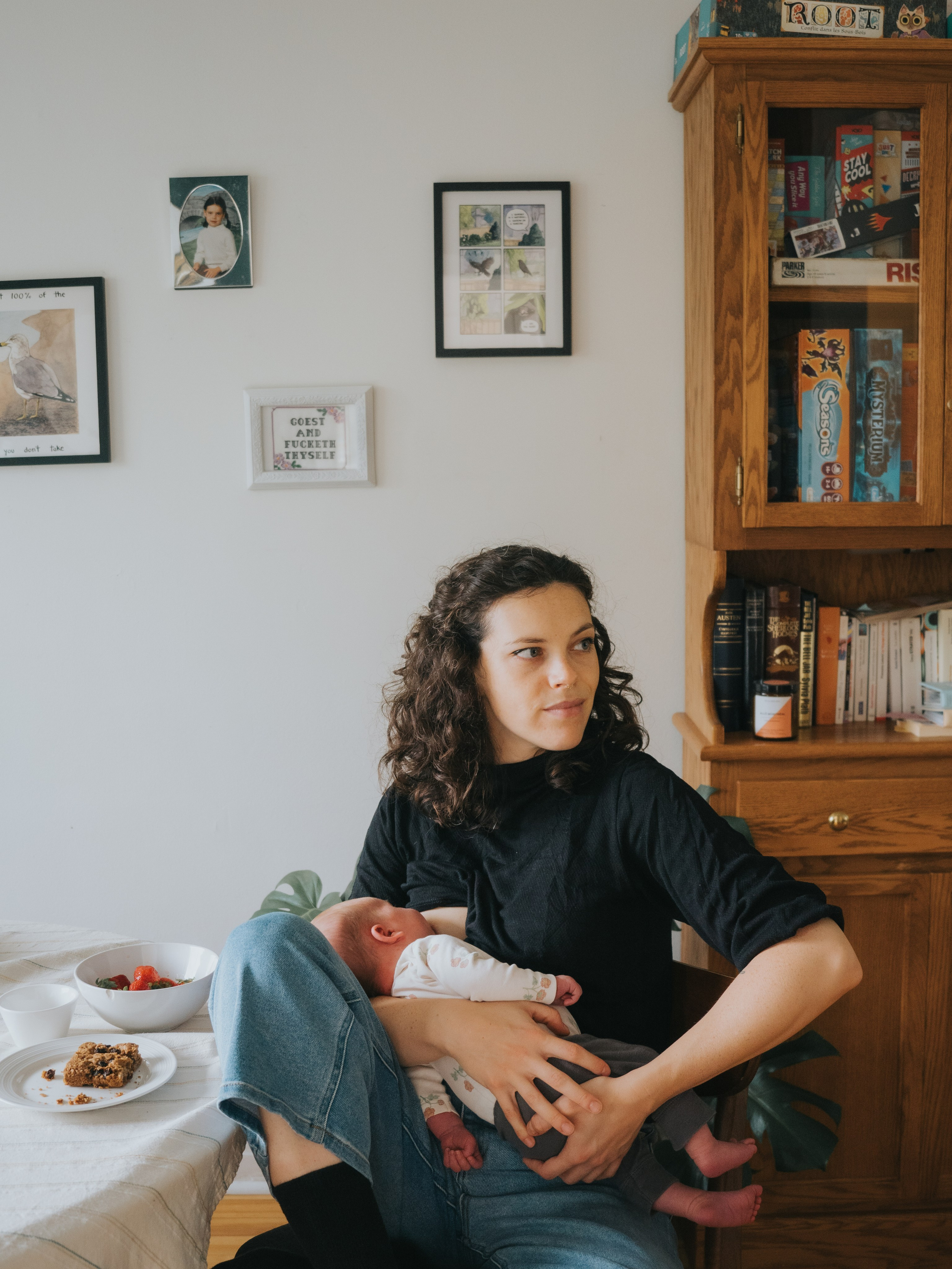 Woman breastfeeding a newborn in her living room.