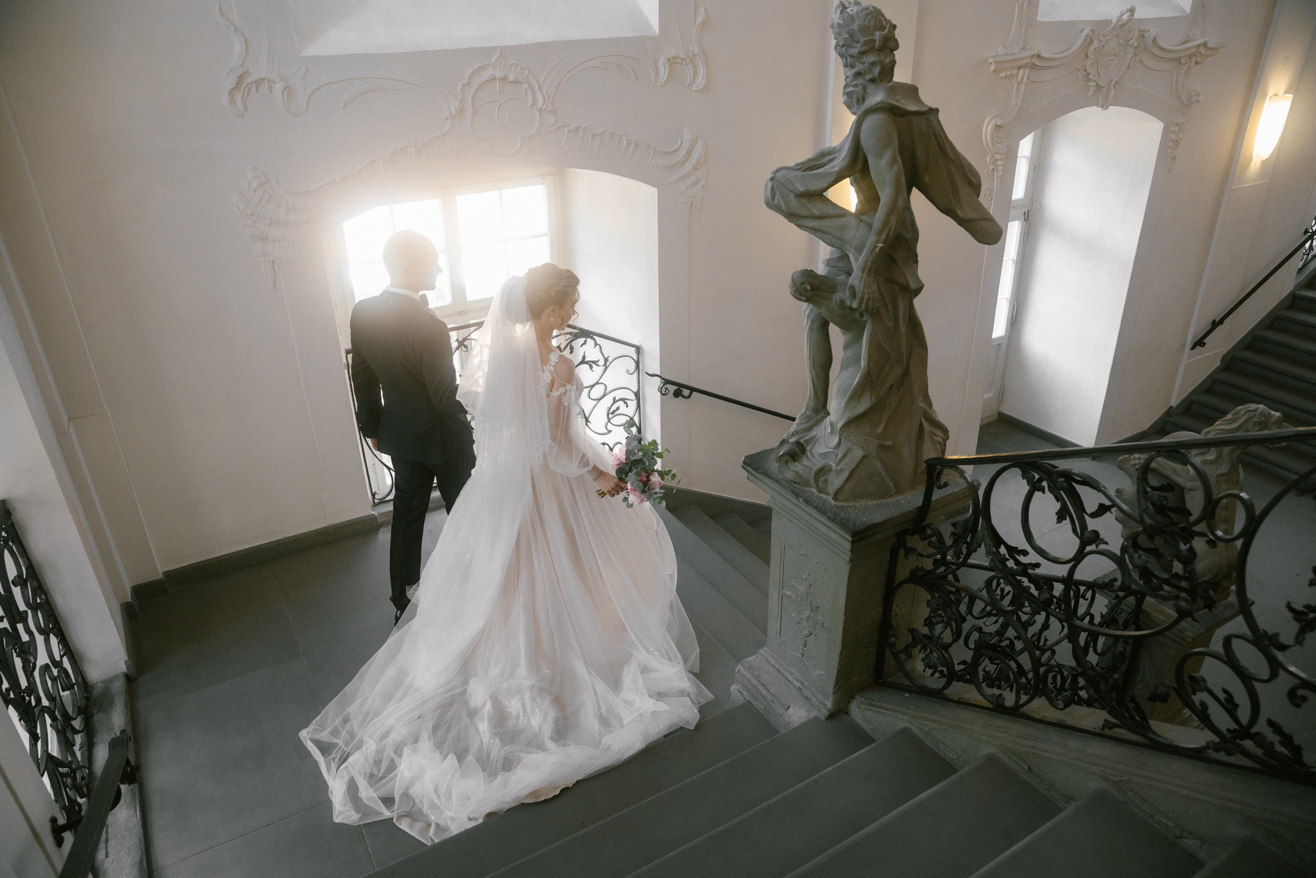 Brautpaar geht die barocke Treppe im Schloss Meersburg gemeinsam hinab