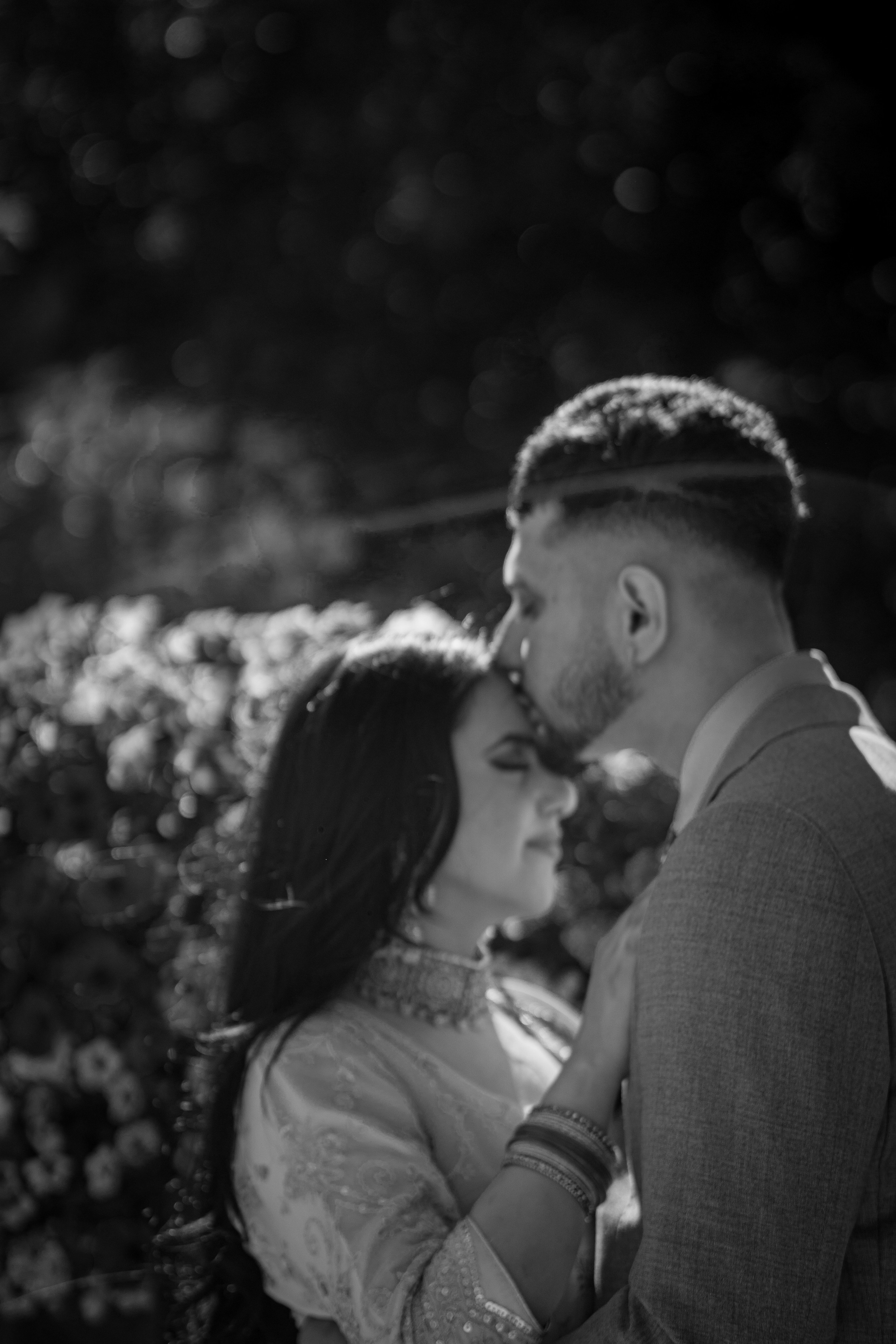 man kissing the forehead of a woman