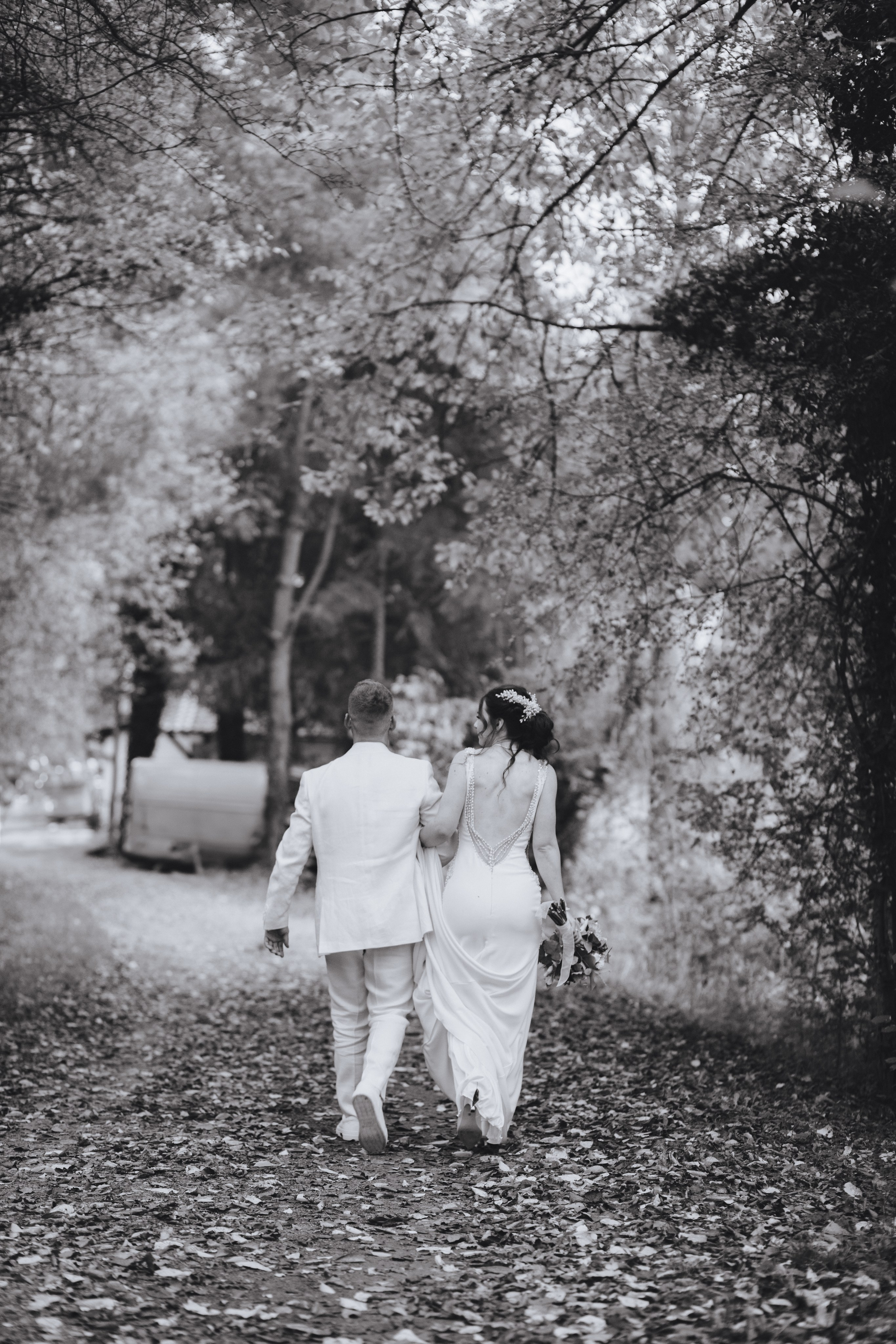 Das Brautpaar spaziert durch den herbstlichen Wald.