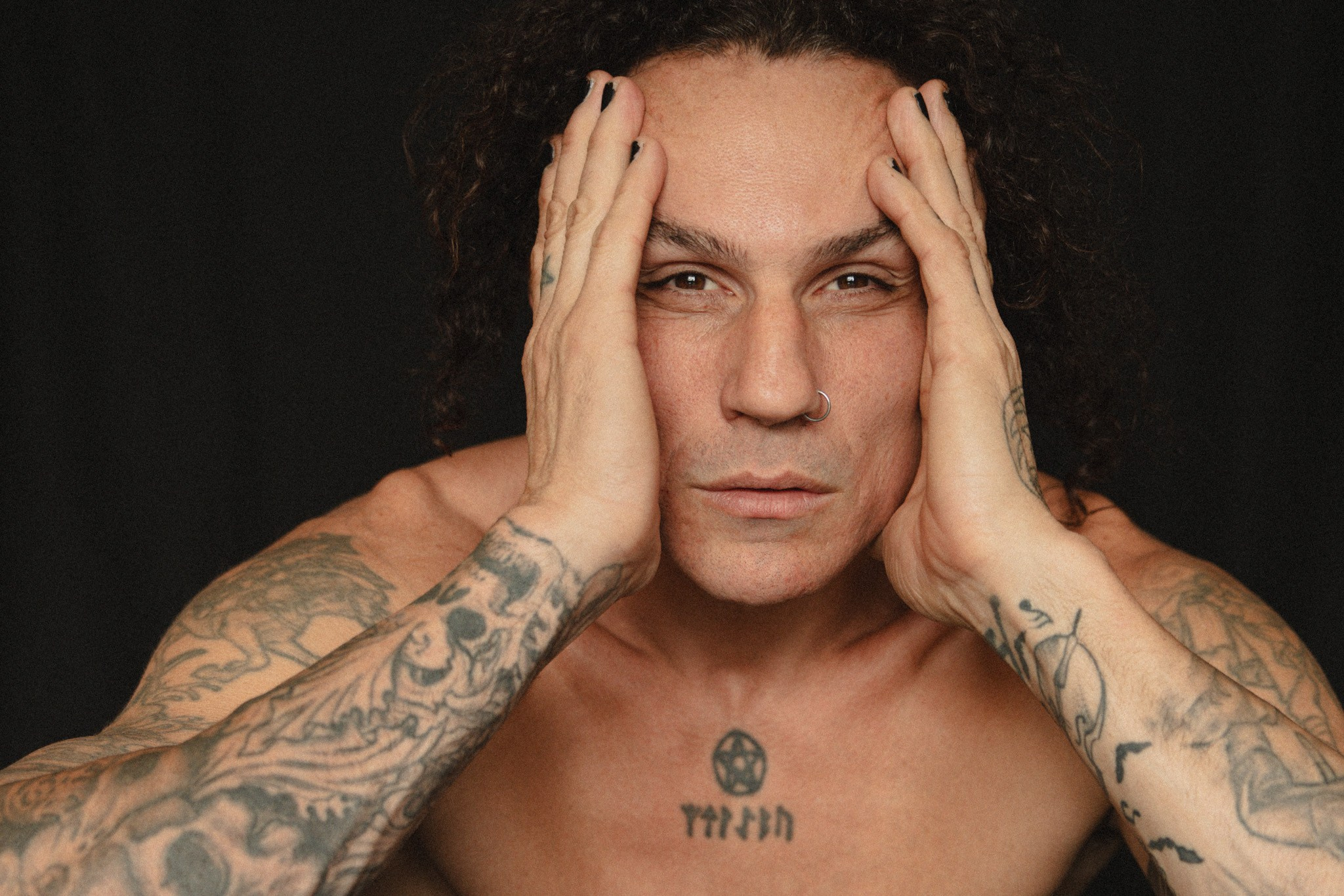 Close-up studio portrait of a tattooed male model