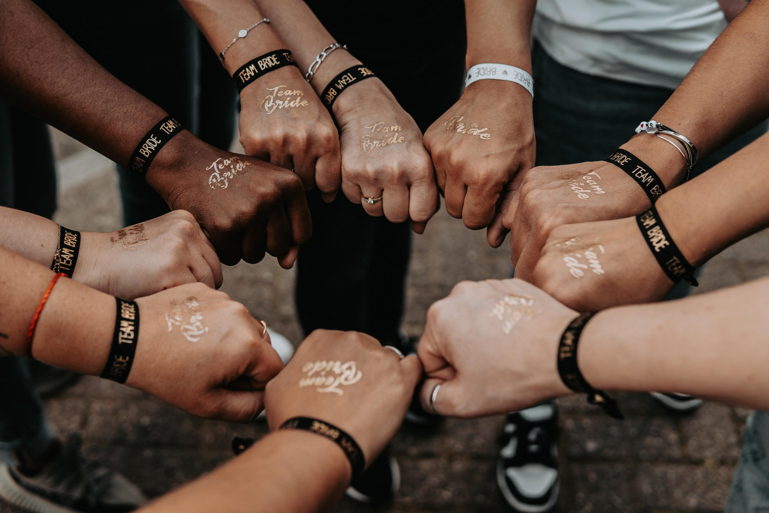 girls showing their fist in a circle manner with team bride written on their back of hand