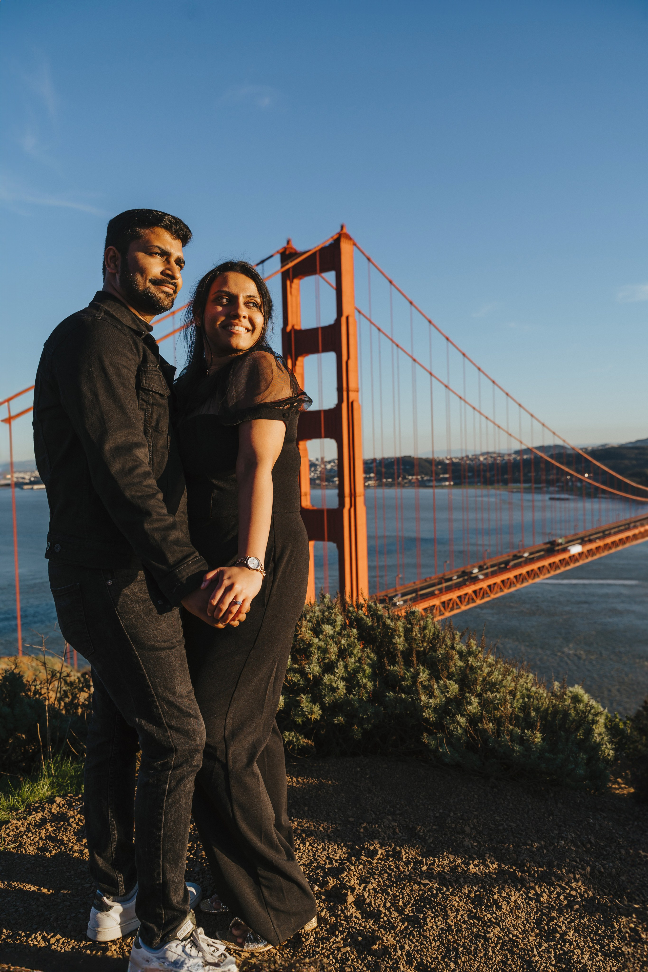 Proposal.  Overlooking the golden San Franisco Bridge sunset with a couple. Photographer Video. 