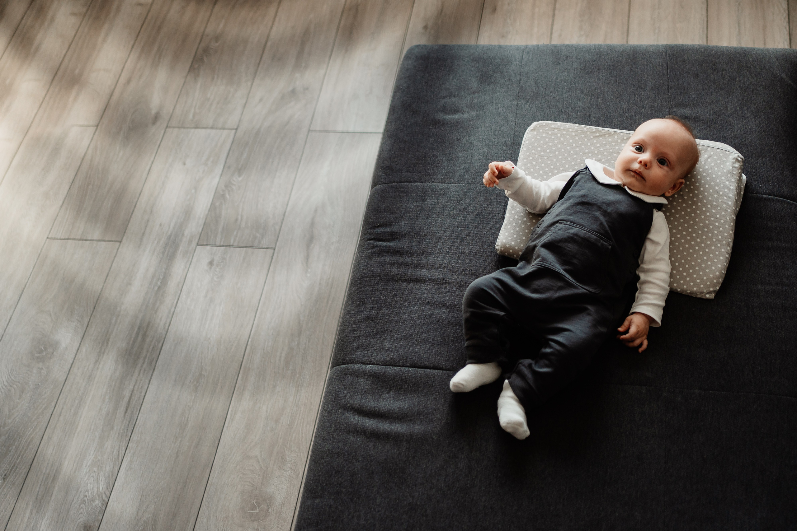 Instantaneu plin de tandrețe dintre părinți și bebeluș în ziua botezului, realizat în Craiova. Fotografie profesională de botez, capturând emoțiile autentice ale familiei într-un decor luminos și cald