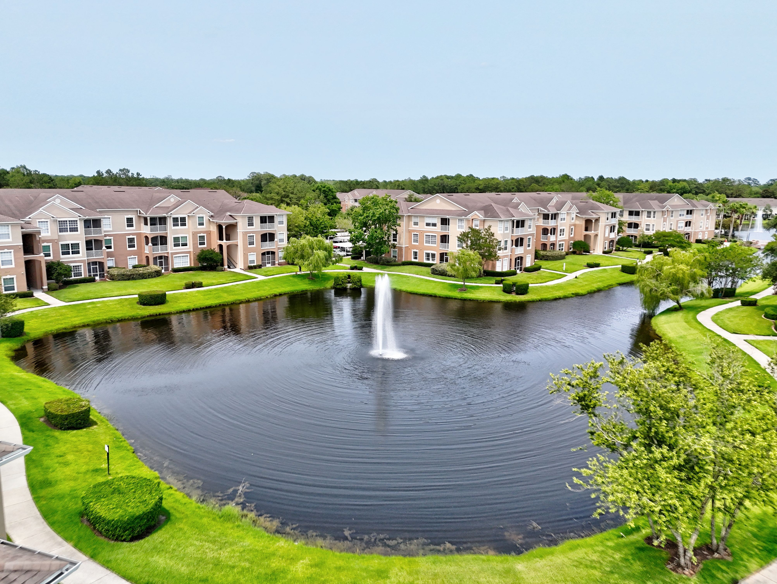 Lakefront community with landscaped lawns and central fountain