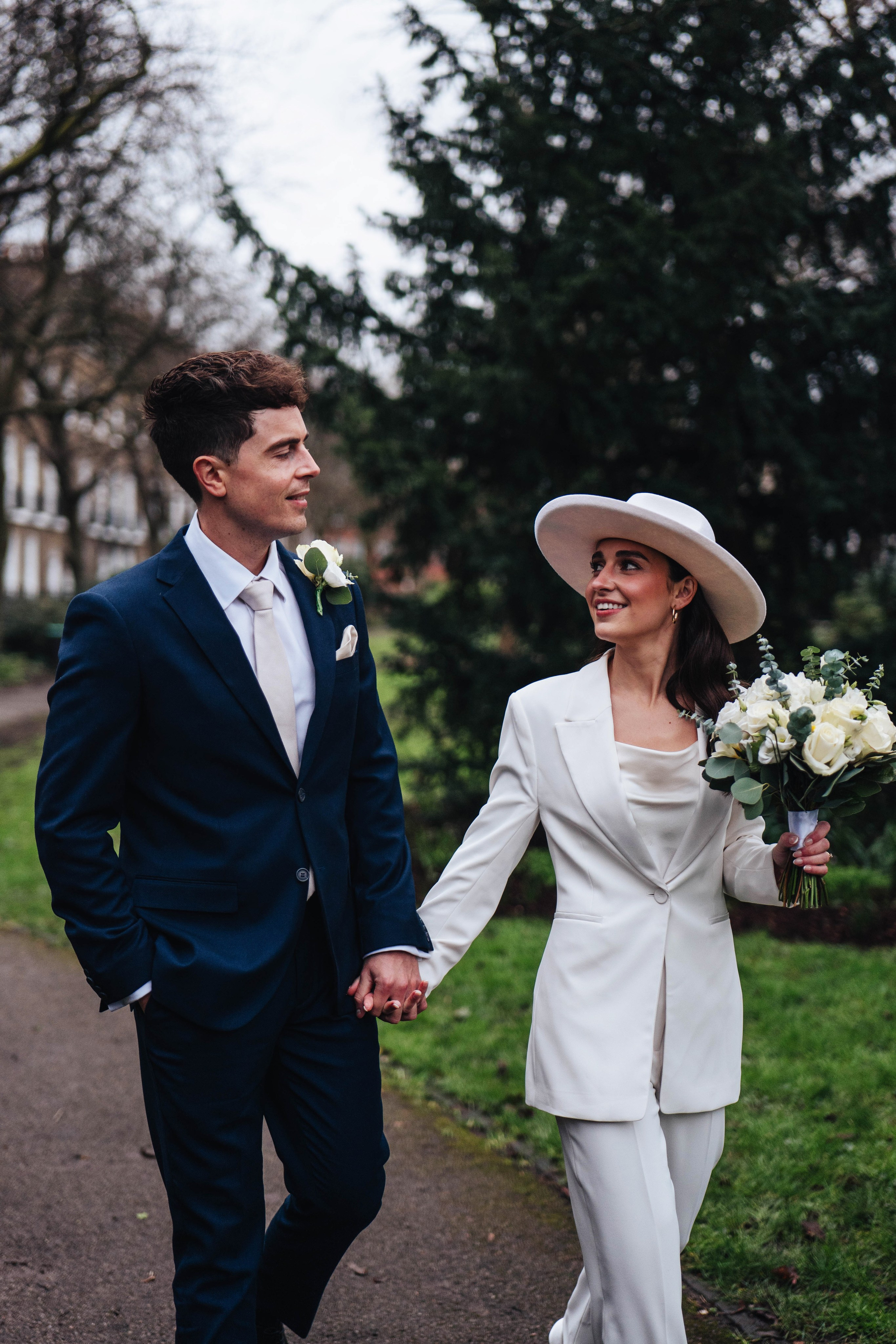 Stylish wedding in Islington, white women costume and white hat, walking in the green area