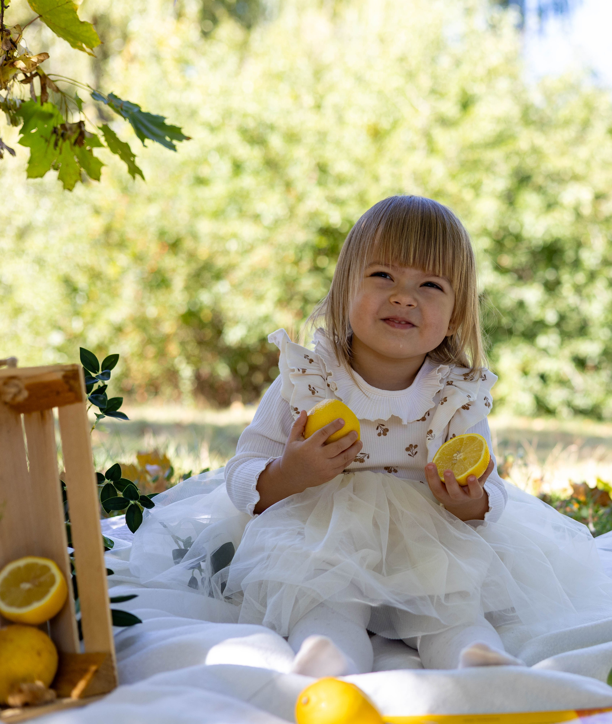 Рука модели держит яркий лимон на контрастном фоне