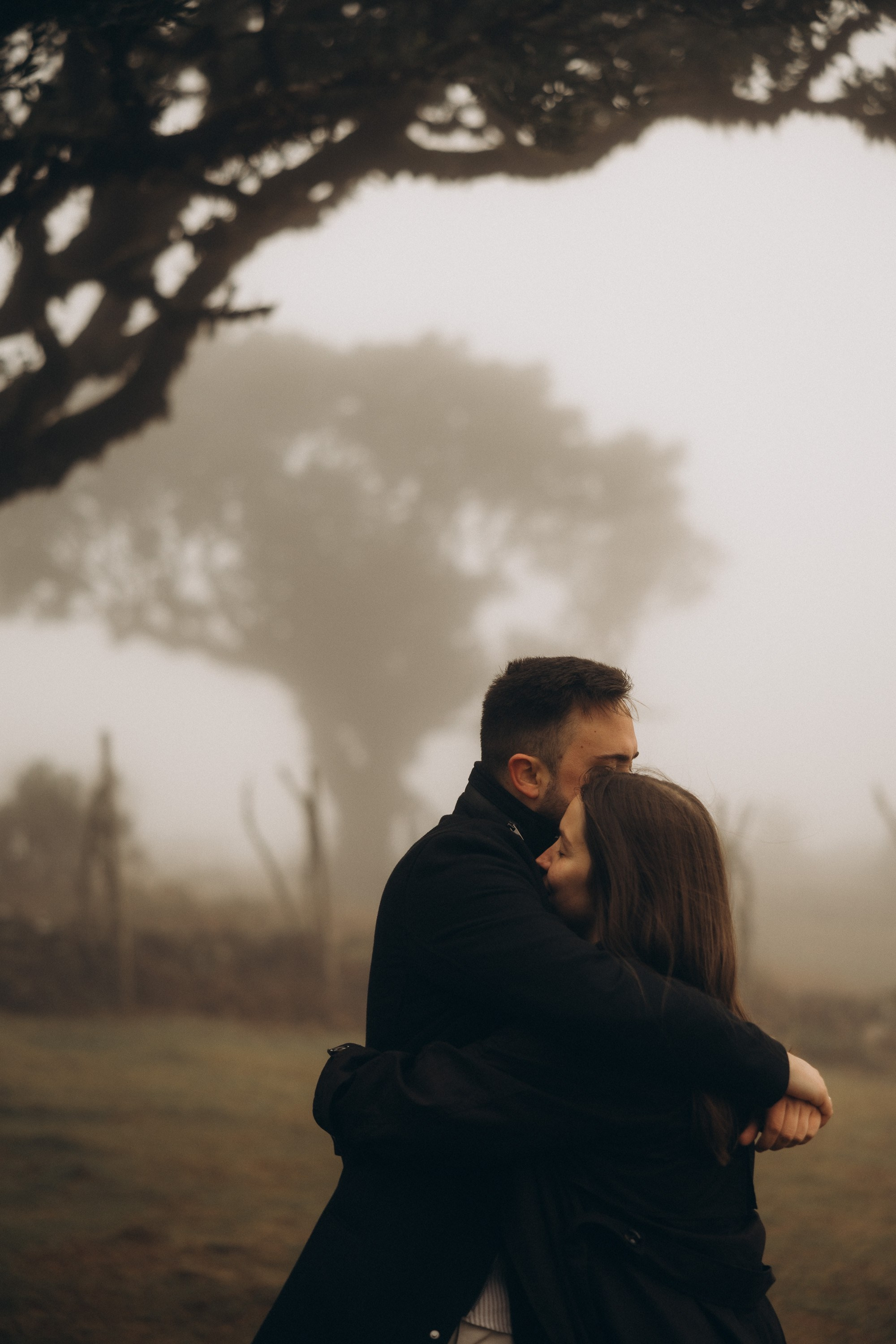 Couple photoshoot in Fanal Forest Madeira PortugalA romantic couple standing amidst the ancient laurel trees of Fanal Forest, Madeira, surrounded by a mystical fog that adds an ethereal touch to the scene