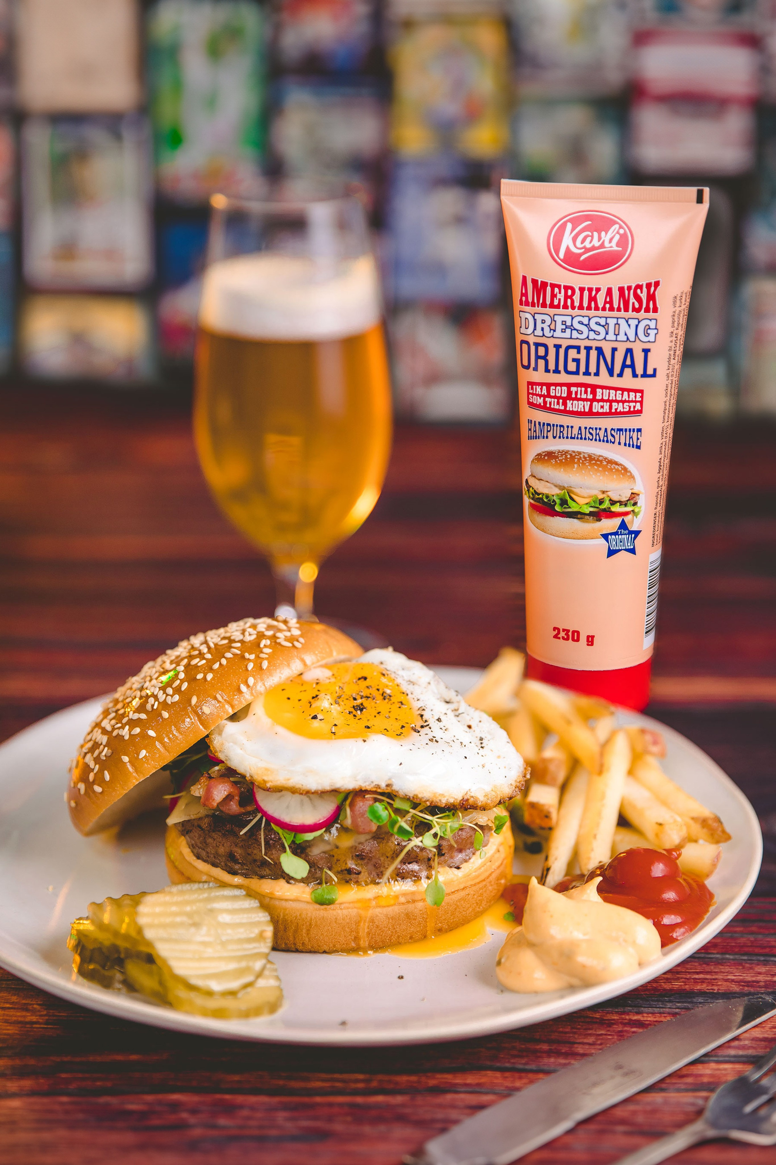 Juicy burger on a plate with some sauce and a a cold beer. Stylising is a key in food photography.