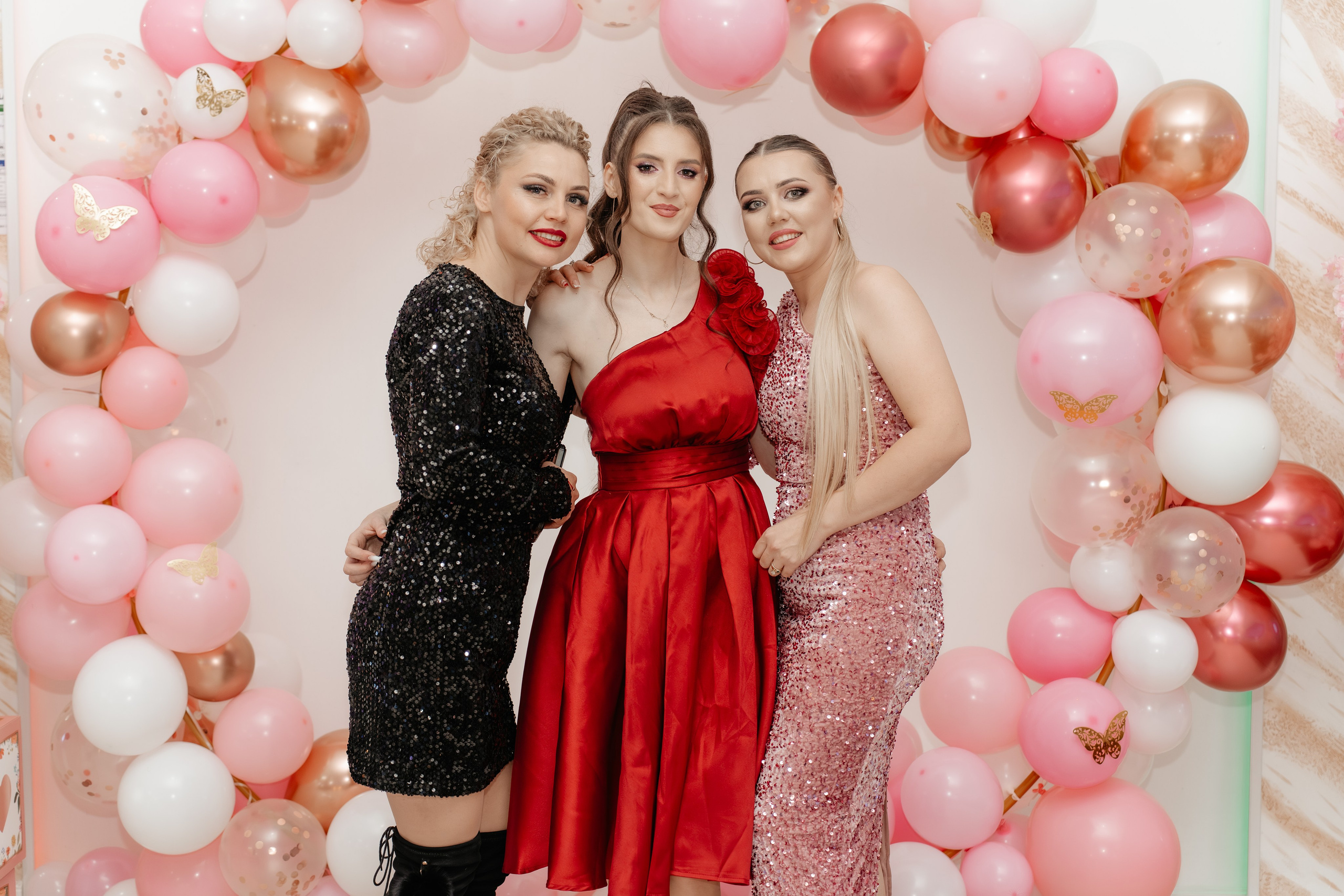 Close-up intim: Maria și una dintre cele mai bune prietene, cu capetele apropiate, râzând sau schimbând o privire plină de înțelegere și fericire la botez. Detaliu emoțional al legăturii feminine.