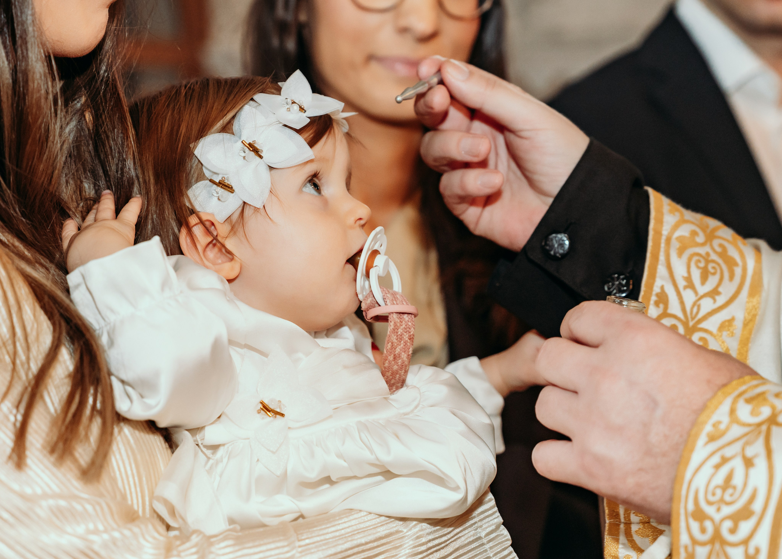 Devojcica se krsti sa vencicem na glavi