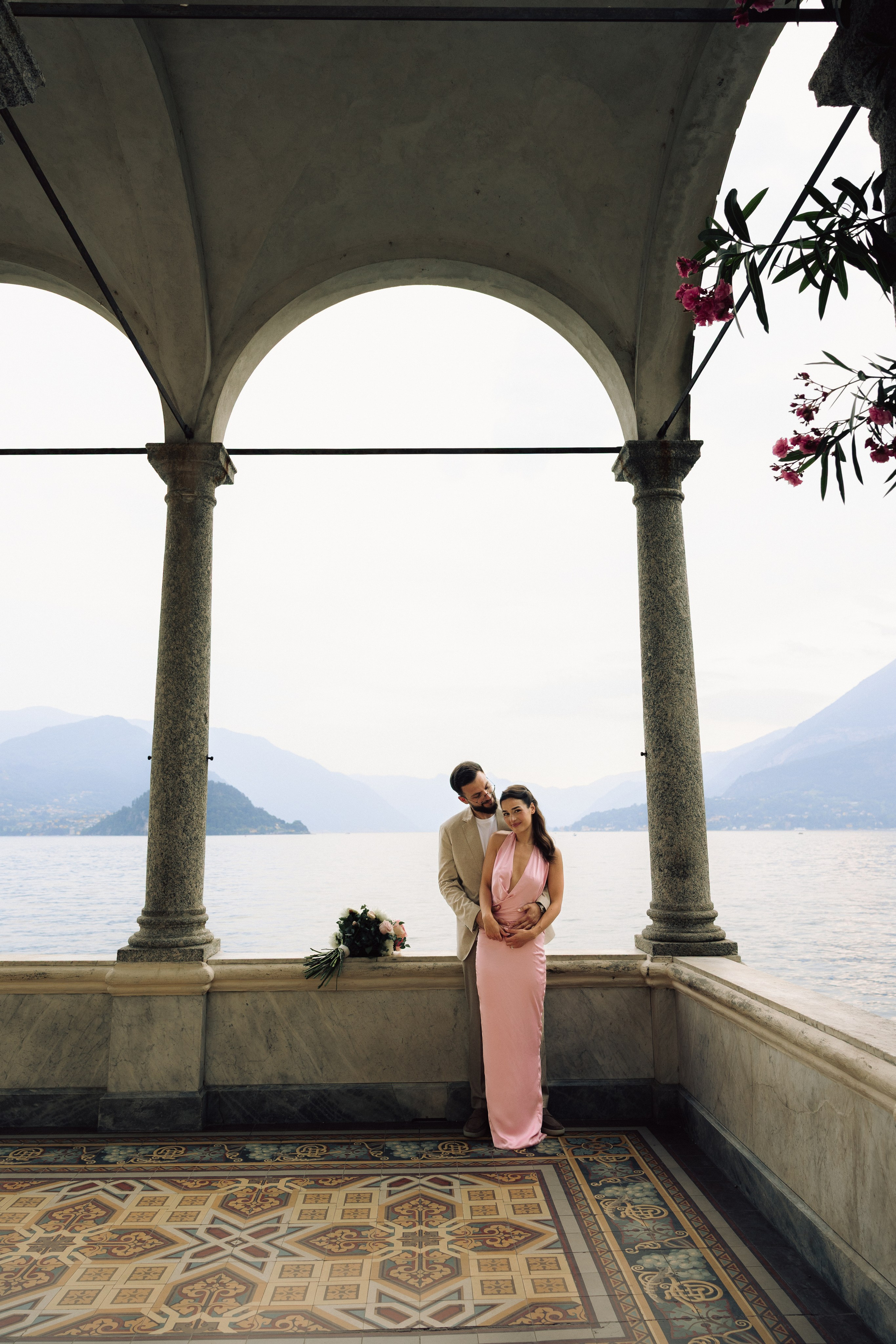 Couple embracing after a surprise engagement proposal on Lake Como at Villa Monastero