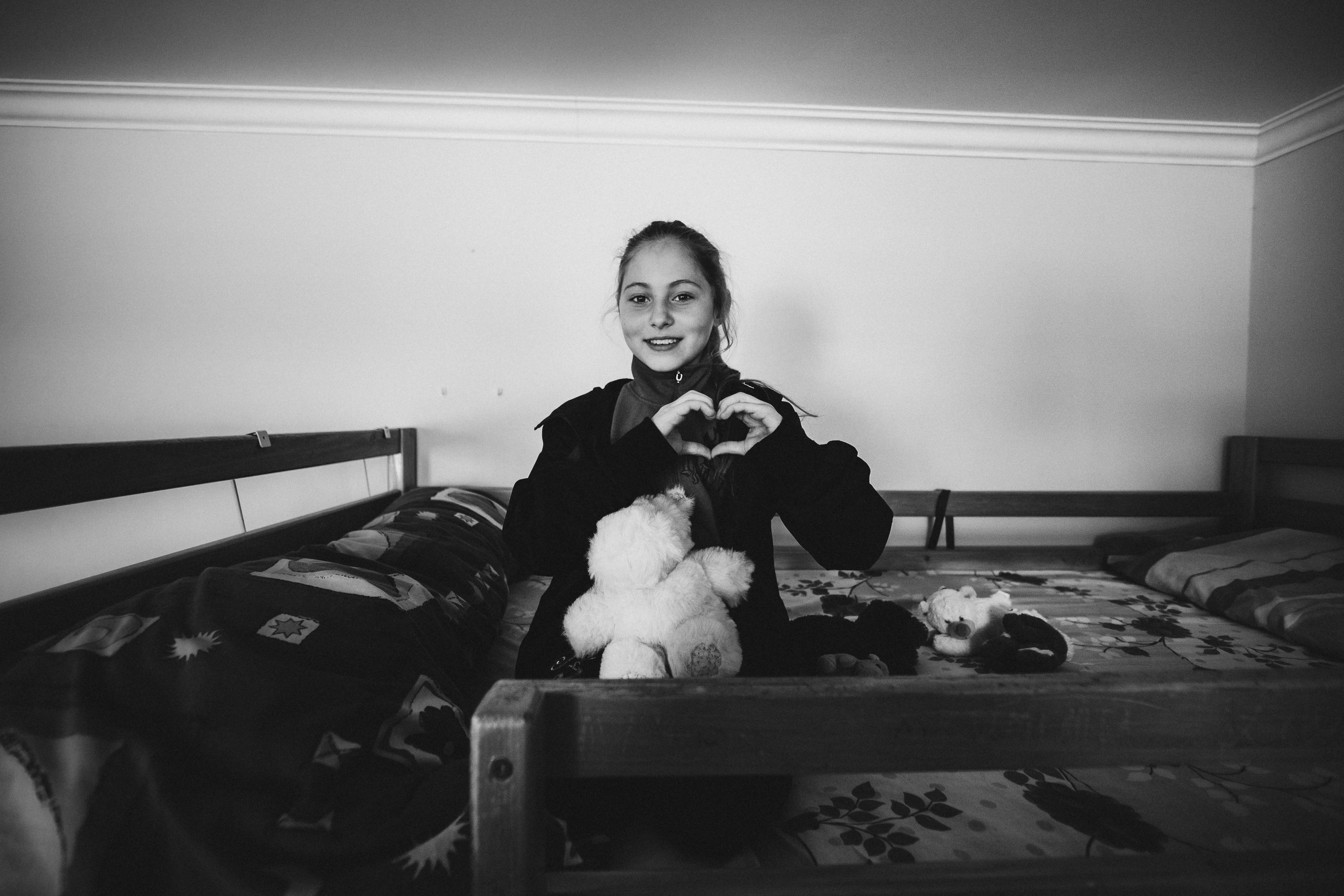 портрет чёрно-белый социальная фотография Детский дом девочка руками показывает форму сердца