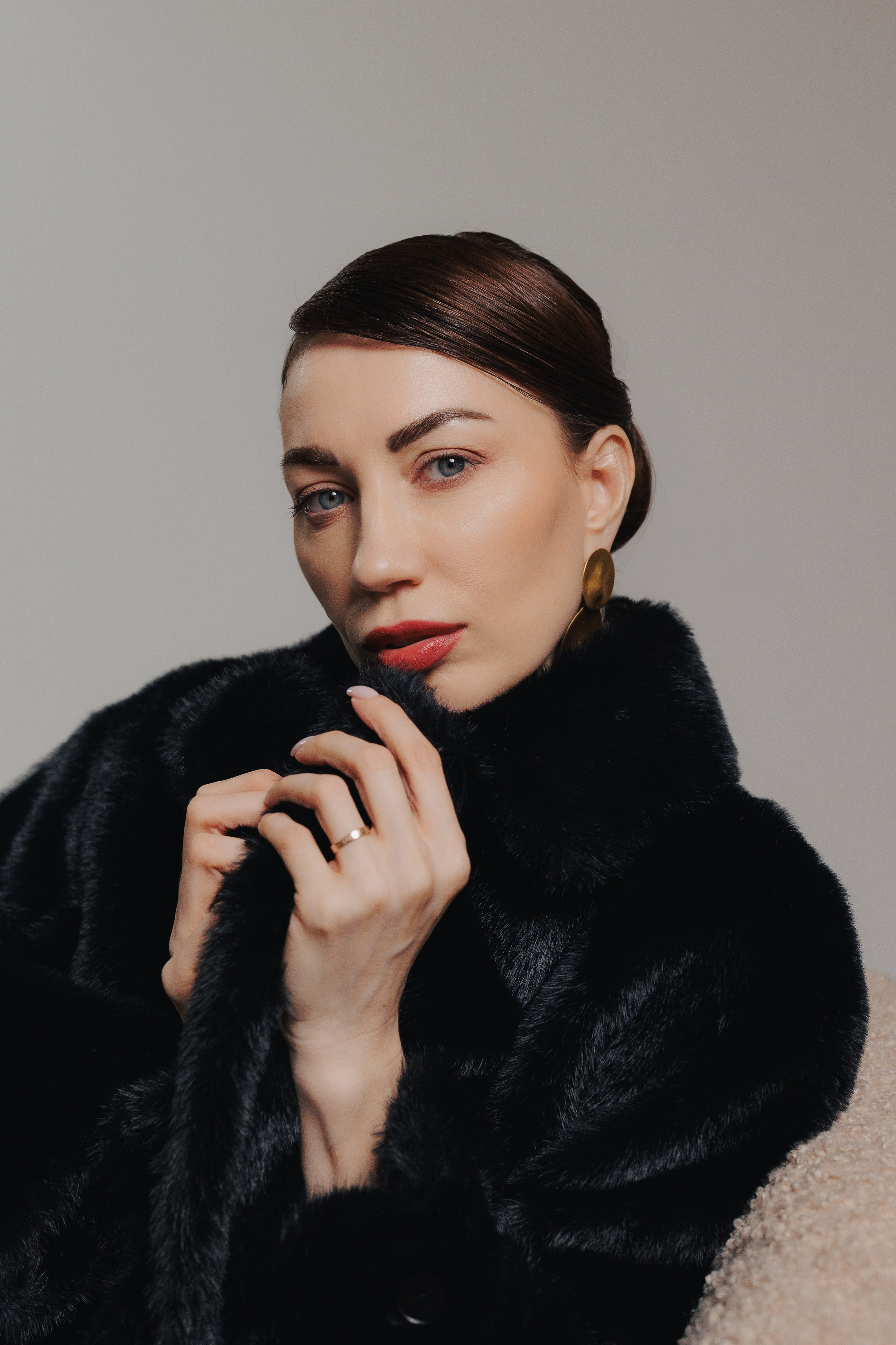 Close-up editorial portrait of a woman in a black fur coat with elegant pose and soft dramatic studio lighting, photographed in Leipzig, Germany. Крупный редакционный портрет девушки в чёрной шубе с элегантной позой и мягким драматичным студийным освещением, снятый в Лейпциге, Германия.