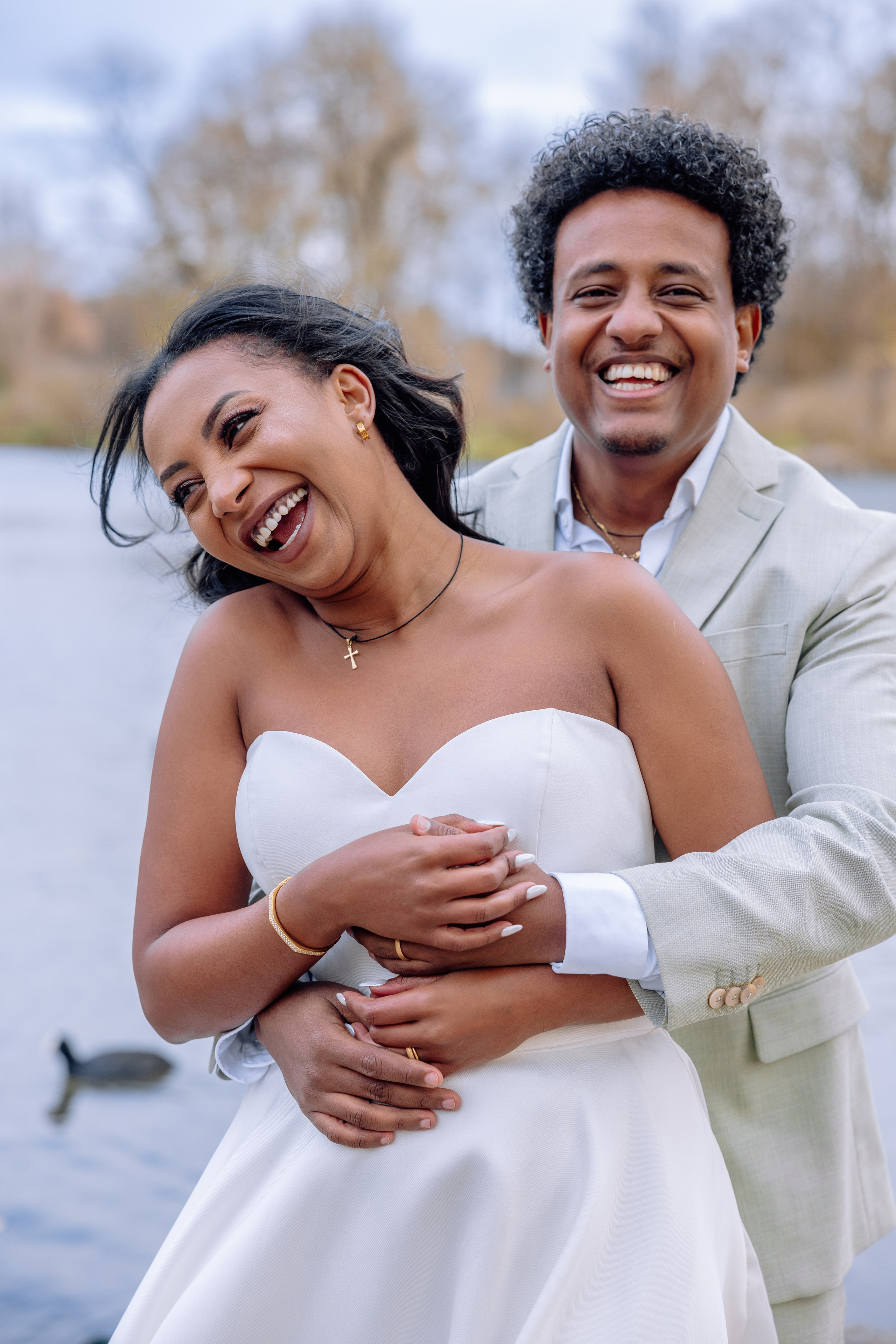 Braut umarmt Bräutigam – spielerischer, liebevoller Moment vor Standesamt Schwabing