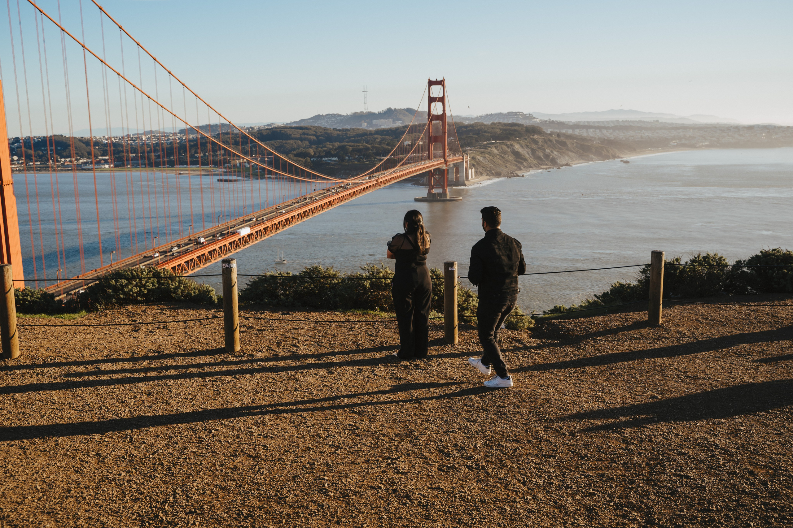 Proposal.  Overlooking the golden San Franisco Bridge sunset with a couple. Photographer Video. 