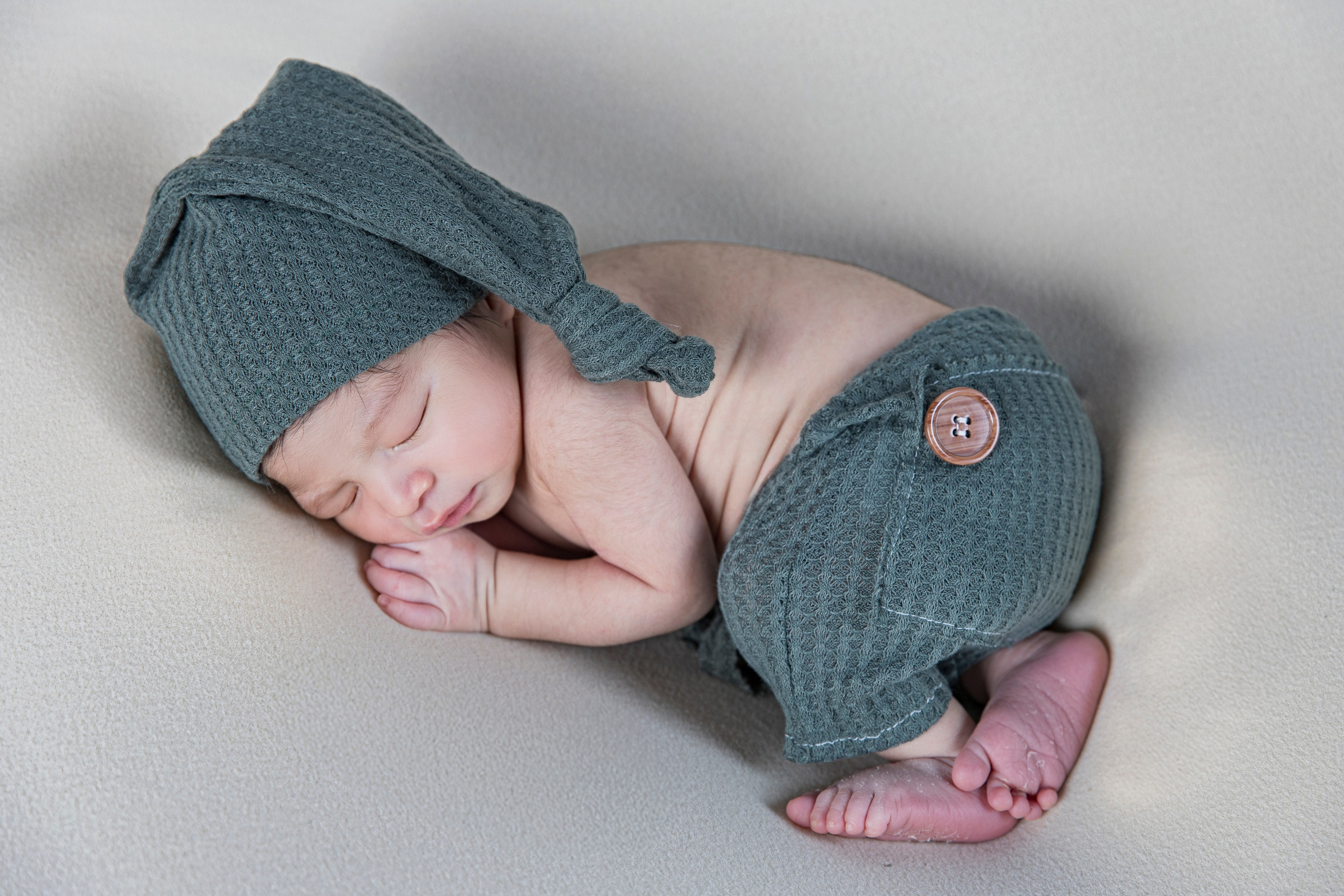 Sesión newborn creativa con bebé en cesta de mimbre y mantitas de lana orgánica, estilo rústico y delicado.