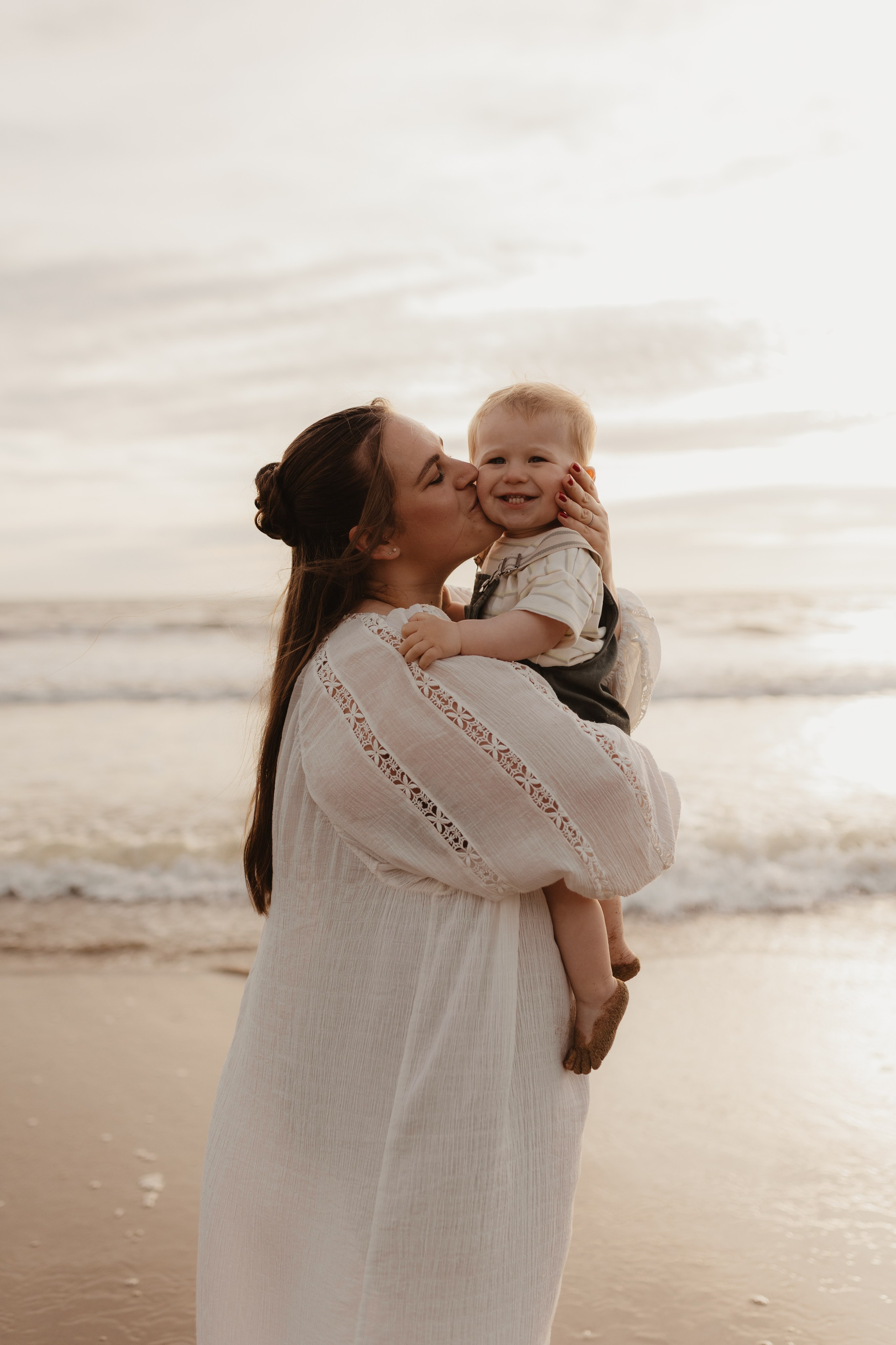 Maman tenant son fils dans ses bras au coucher du soleil, instant tendre et spontané